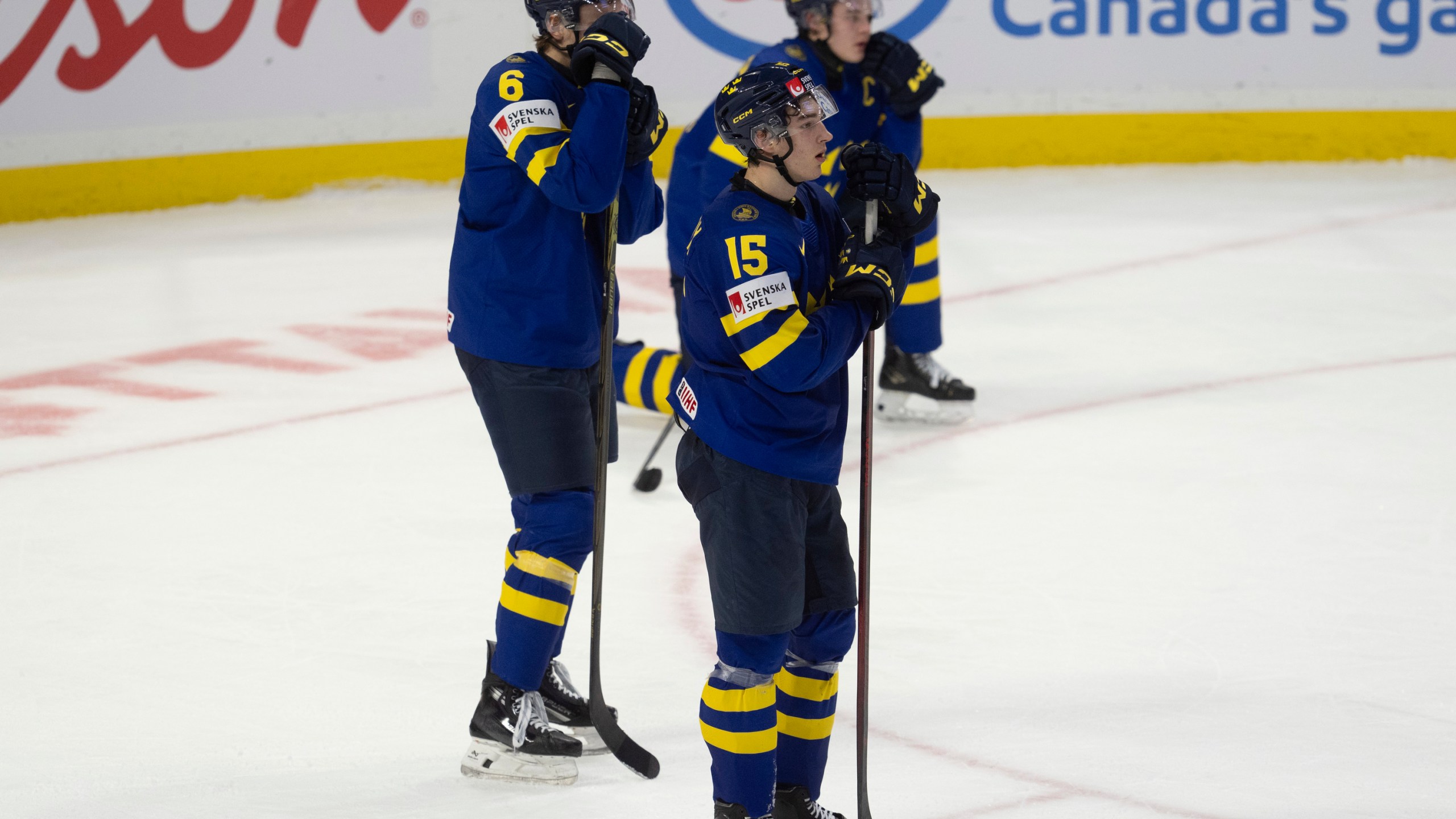 Sweden forward David Edstrom (15) and teammates Axel Hurtig (6) and Axel Sandin Pellikka react after losing in overtime against Finland in semifinal game at the world junior hockey championship, Saturday, Jan. 4, 2025 in Ottawa, Ontario. (Adrian Wyld/The Canadian Press via AP)