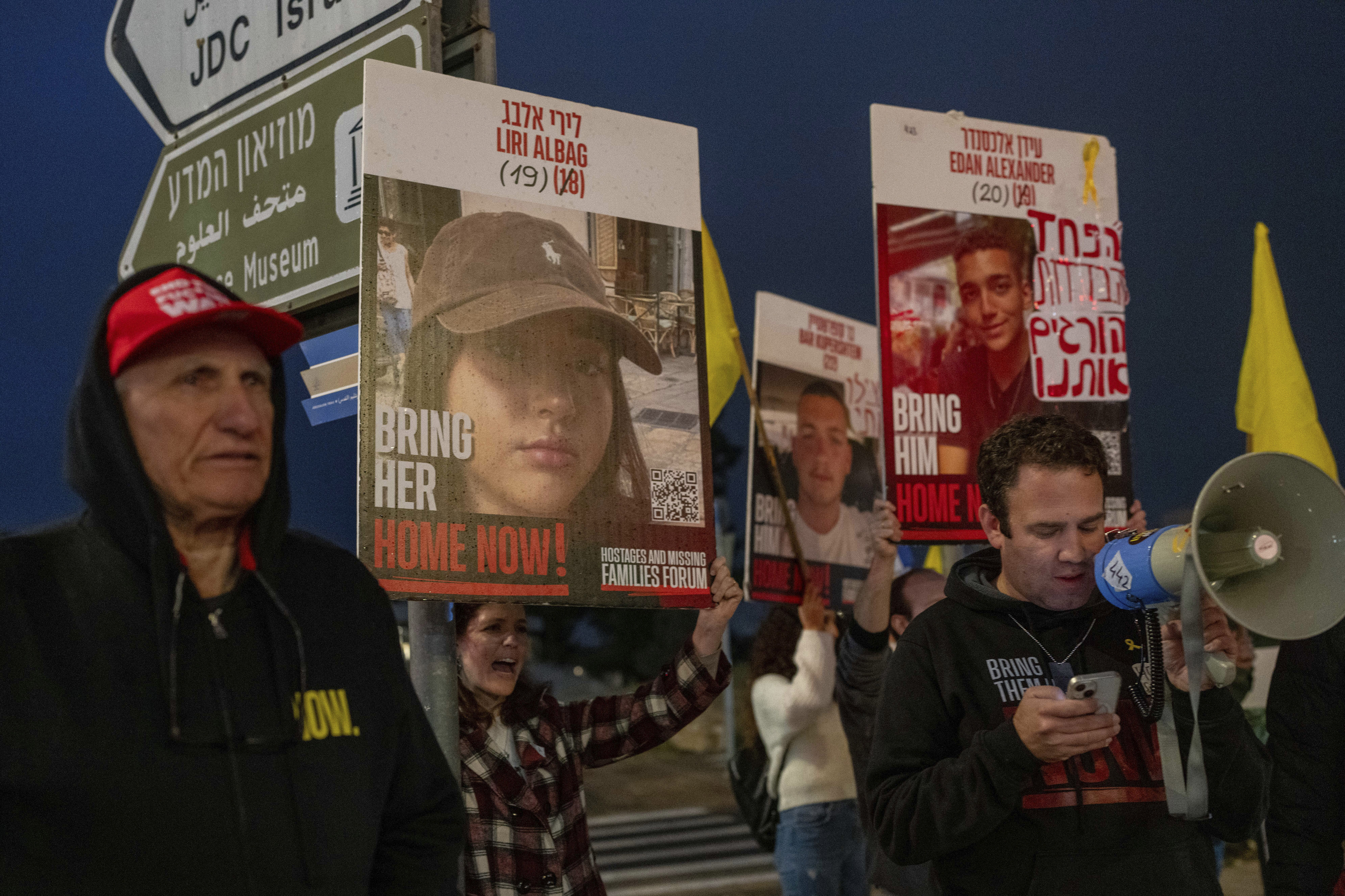 Israeli demonstrators outside the prime minister's office in Jerusalem hold photos of Liri Albag and other hostages during a protest calling for their release from being held in the Gaza Strip by the Hamas militant group, Sunday, Jan. 5, 2025. (AP Photo/Ohad Zwigenberg)