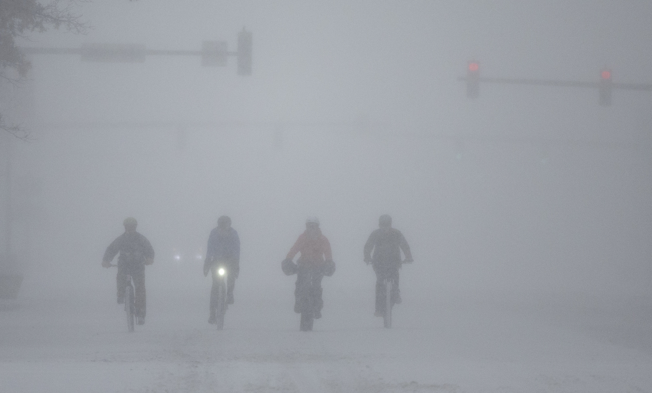 A group of cyclists make way through downtown Wichita, Kan., during a severe winter storm on Sunday, Jan. 5, 2025. (Travis Heying/The Wichita Eagle via AP)