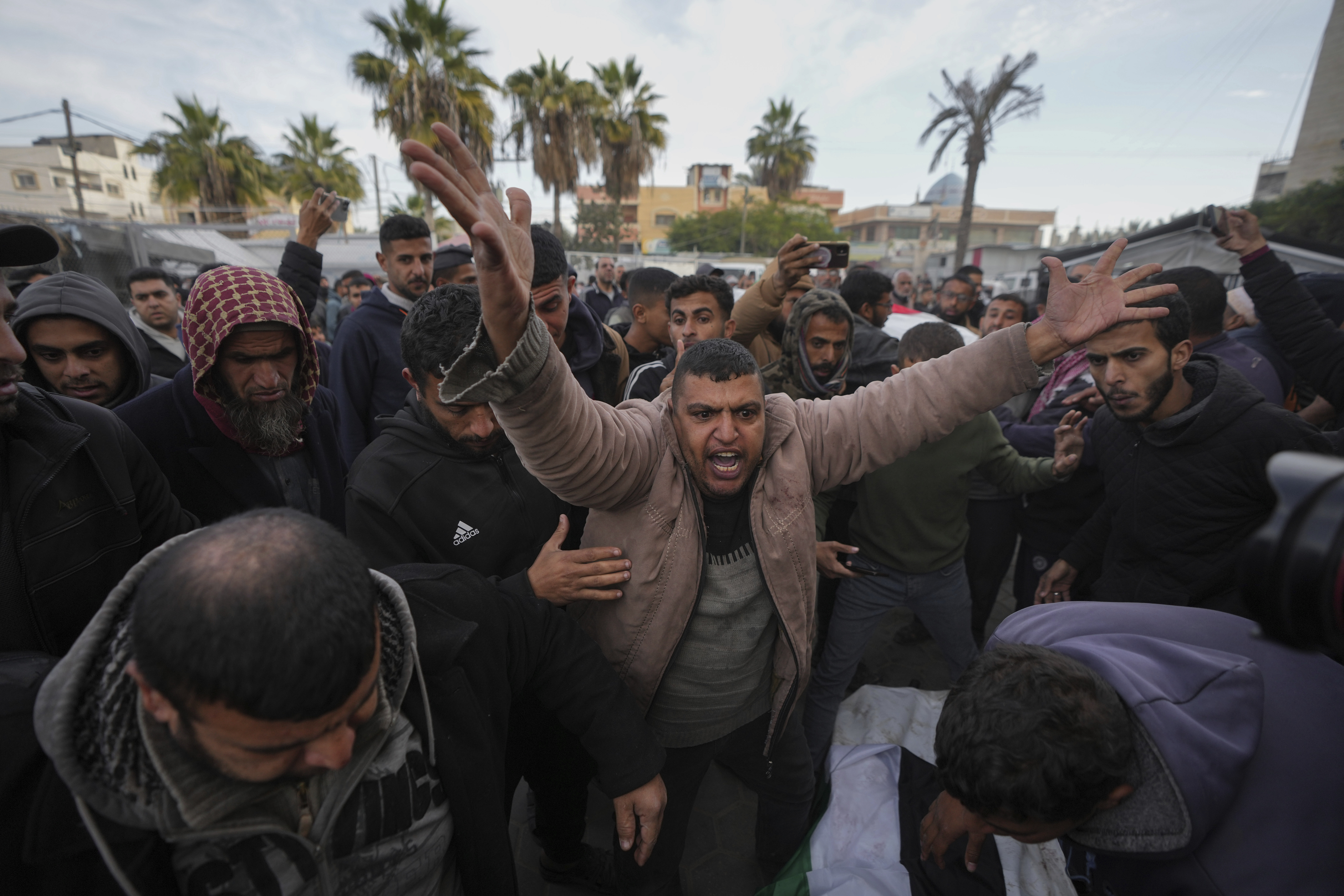 Palestinians mourn their relatives killed in the Israeli bombardment of the Gaza Strip, at Al-Aqsa Martyrs Hospital in Deir al-Balah, Sunday, Jan. 5, 2025. (AP Photo/Abdel Kareem Hana)