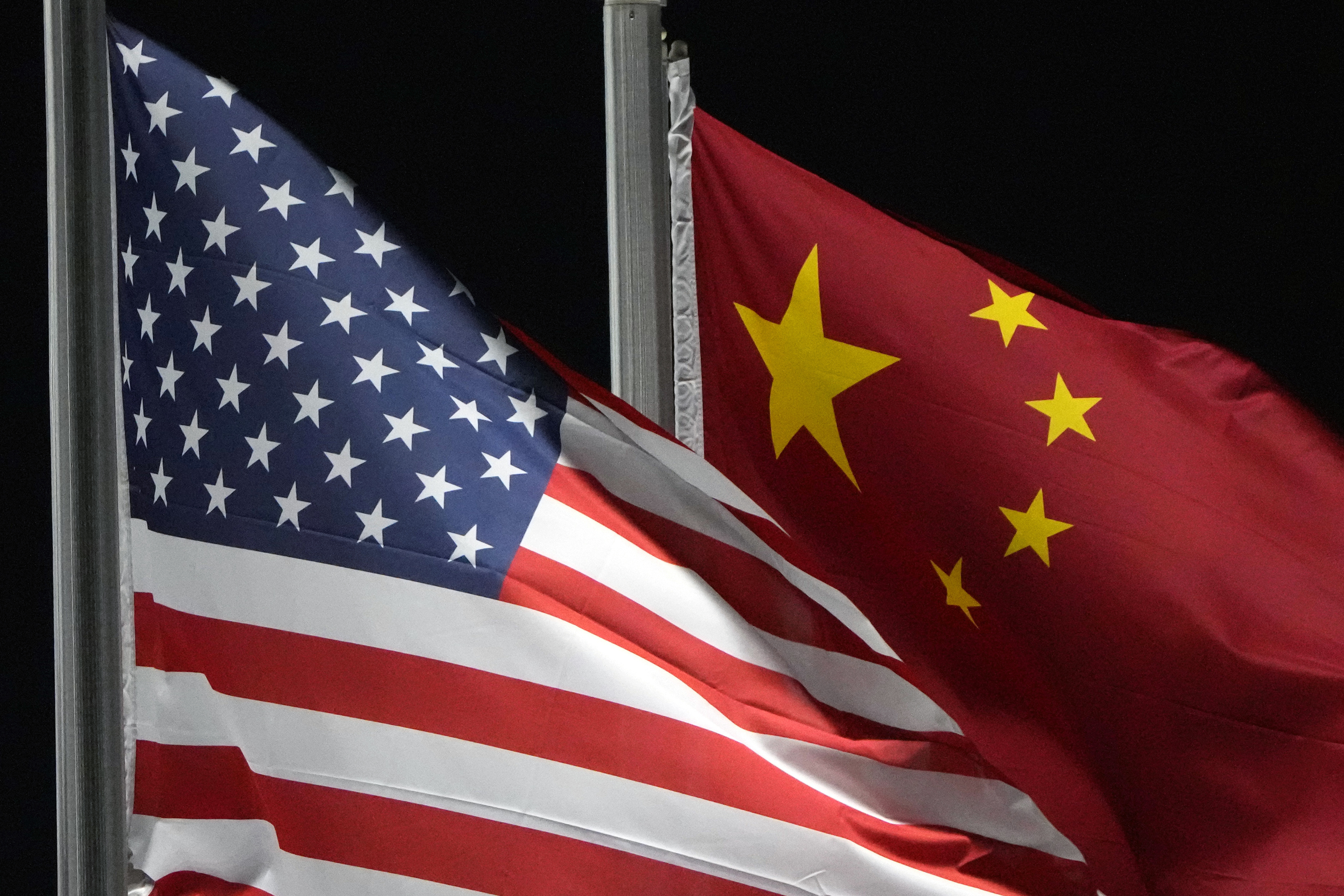 FILE - The American and Chinese flags wave at Genting Snow Park ahead of the 2022 Winter Olympics, Feb. 2, 2022, in Zhangjiakou, China. (AP Photo/Kiichiro Sato, File)