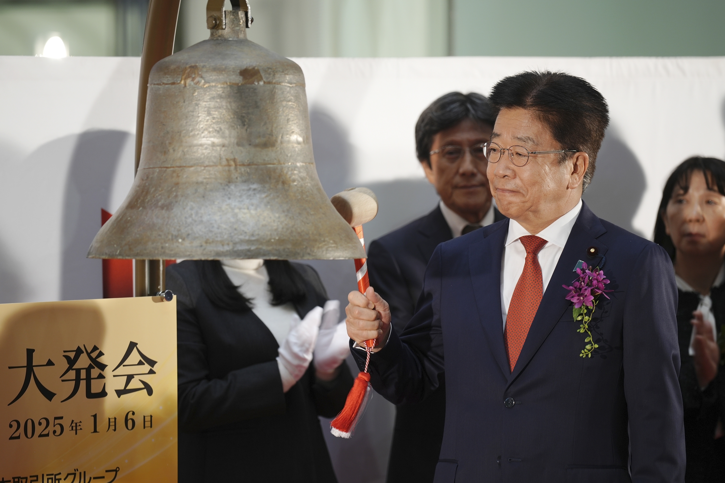 Japan's Finance Minister Katsunobu Kato tolls a bell during a ceremony marking the start of this year's trading Monday, Jan. 6, 2025, in Tokyo. (AP Photo/Eugene Hoshiko)