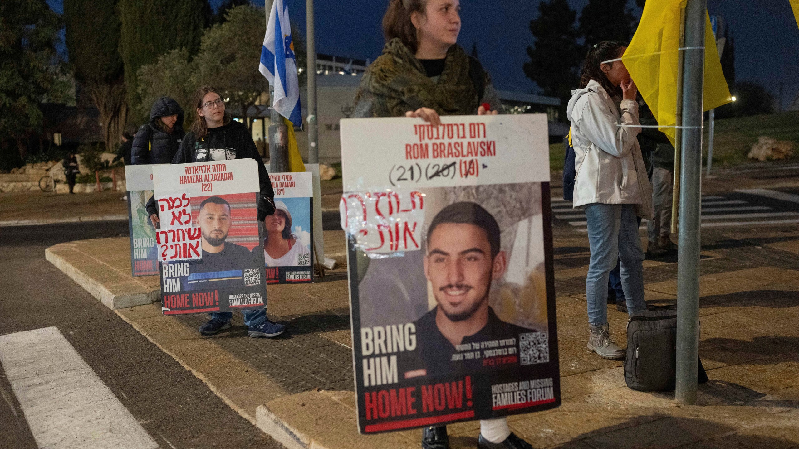 Israeli demonstrators outside the prime minister's office in Jerusalem hold photos of the hostages during a protest calling for the release of hostages held in the Gaza Strip by the Hamas militant group, Sunday, Jan. 5, 2025. (AP Photo/Ohad Zwigenberg)