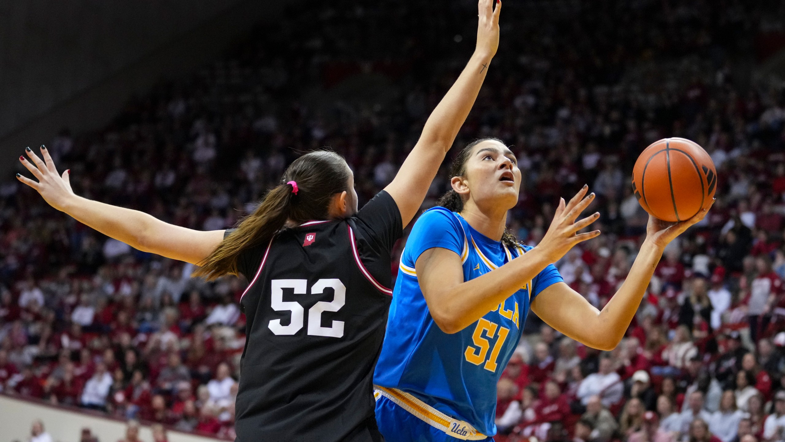 UCLA center Lauren Betts (51) shoots over Indiana forward Lilly Meister (52) in the second half of an NCAA college basketball game in Bloomington, Ind., Saturday, Jan. 4, 2025. (AP Photo/Michael Conroy)