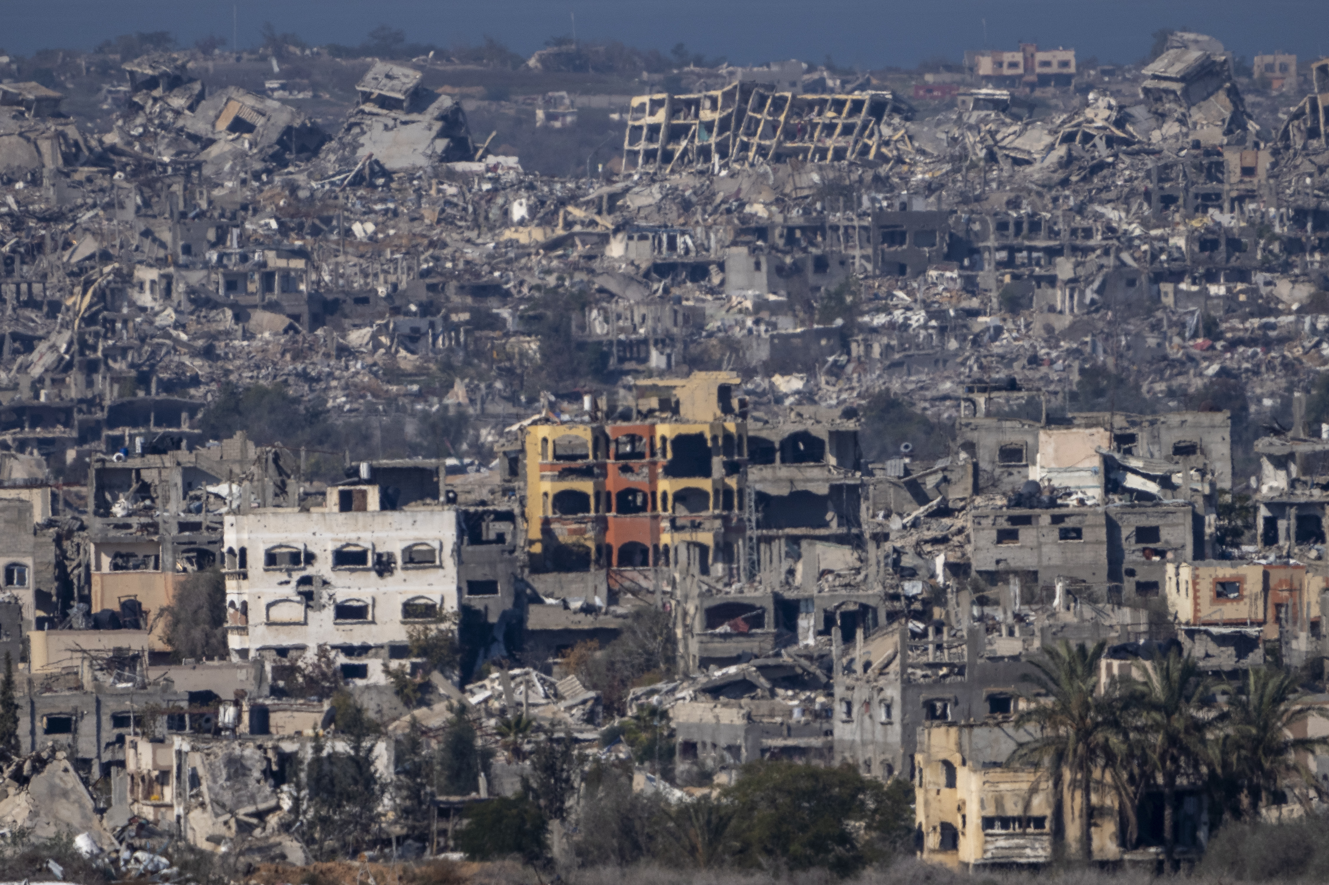 Destroyed buildings stand inside the Gaza Strip, as seen from southern Israel, Tuesday, Jan. 7, 2025. (AP Photo/Ariel Schalit)