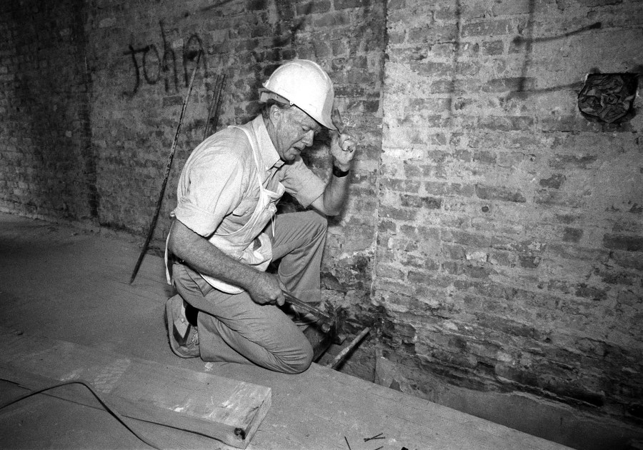 FILE - Former President Jimmy Carter works on a renovation of a tenement building in New York's Lower East Side neighborhood, Sept. 3, 1984. Carter, along with 50 other volunteers from Georgia, are working to build new homes for 19 families as part of the Habitat for Humanity project. (AP Photo/Mario Cabrera, File)