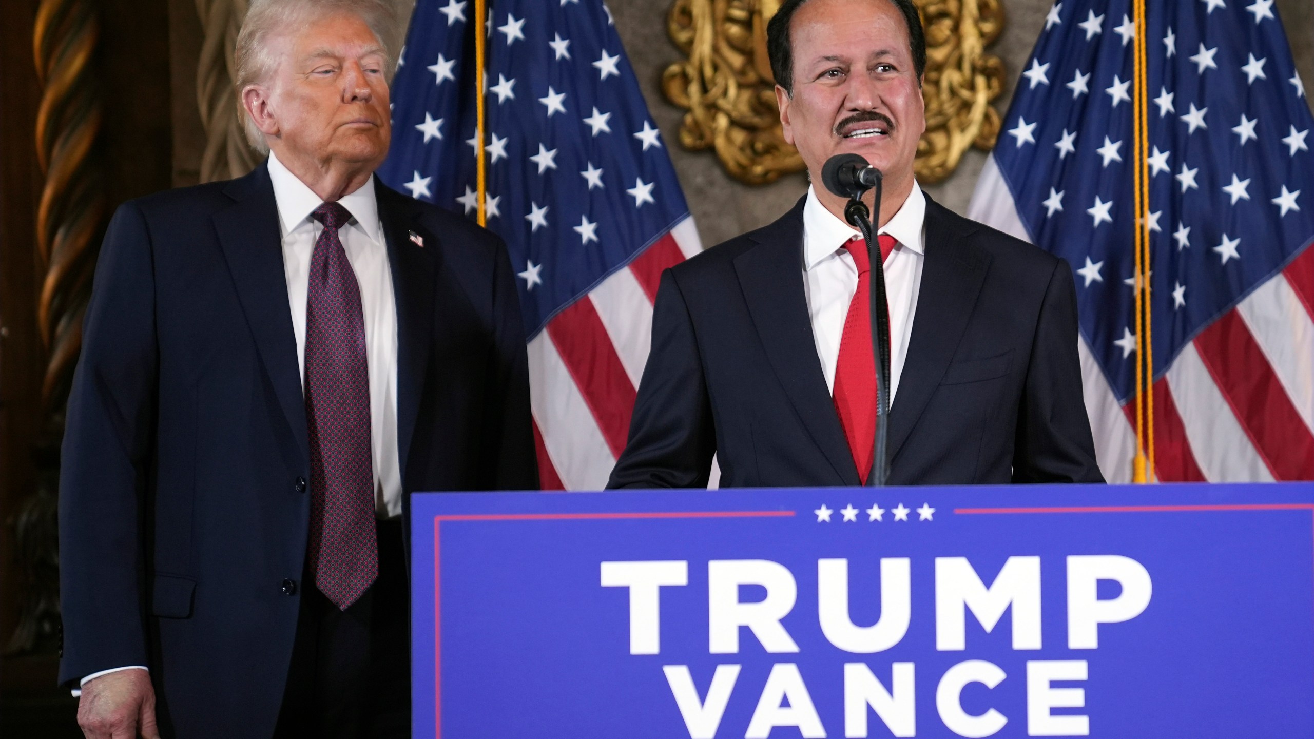 President-elect Donald Trump listens as Hussain Sajwani, CEO of DAMAC Properties, speaks during a news conference at Mar-a-Lago, Tuesday, Jan. 7, 2024, in Palm Beach, Fla. (AP Photo/Evan Vucci)