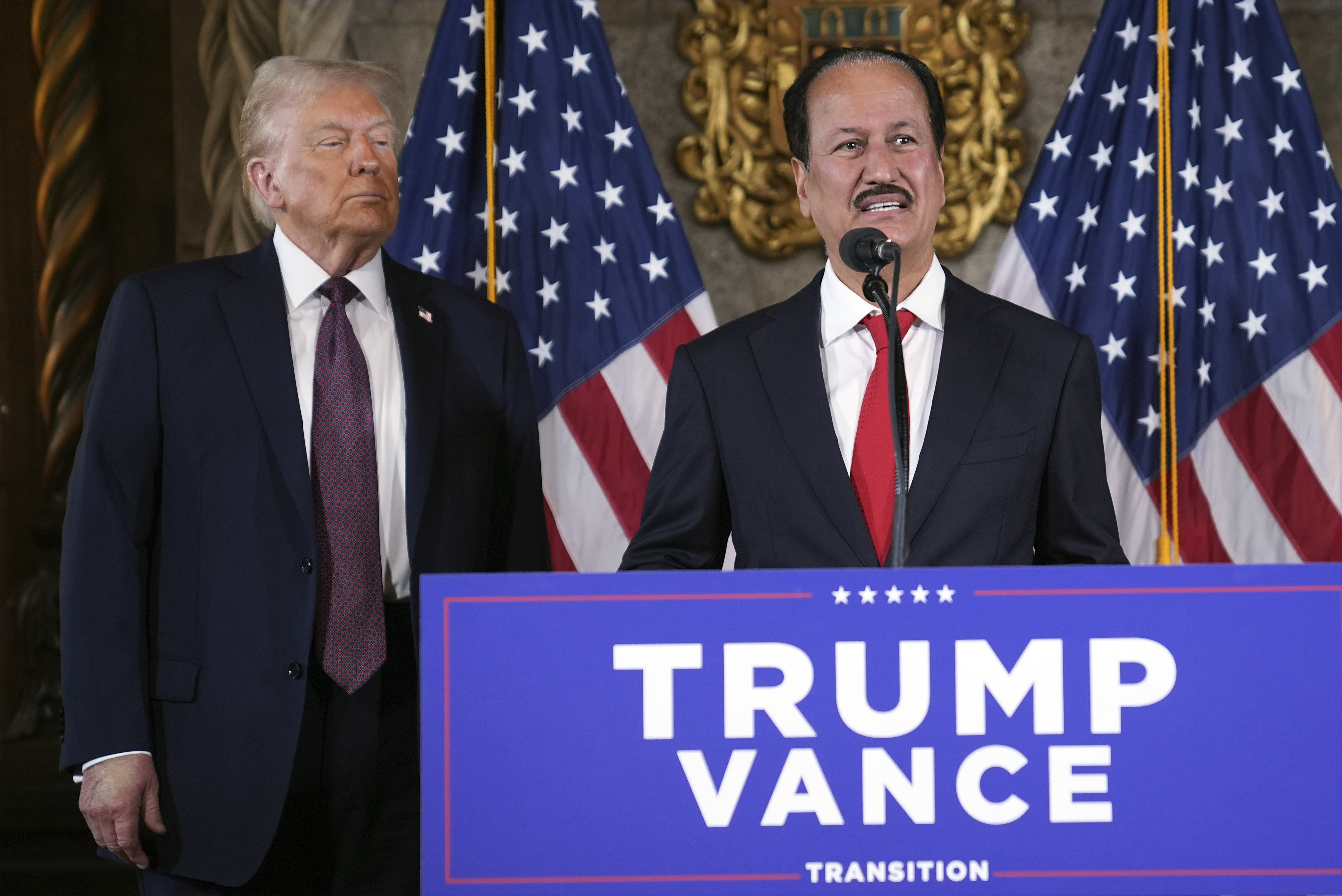 President-elect Donald Trump listens as Hussain Sajwani, CEO of DAMAC Properties, speaks during a news conference at Mar-a-Lago, Tuesday, Jan. 7, 2024, in Palm Beach, Fla. (AP Photo/Evan Vucci)