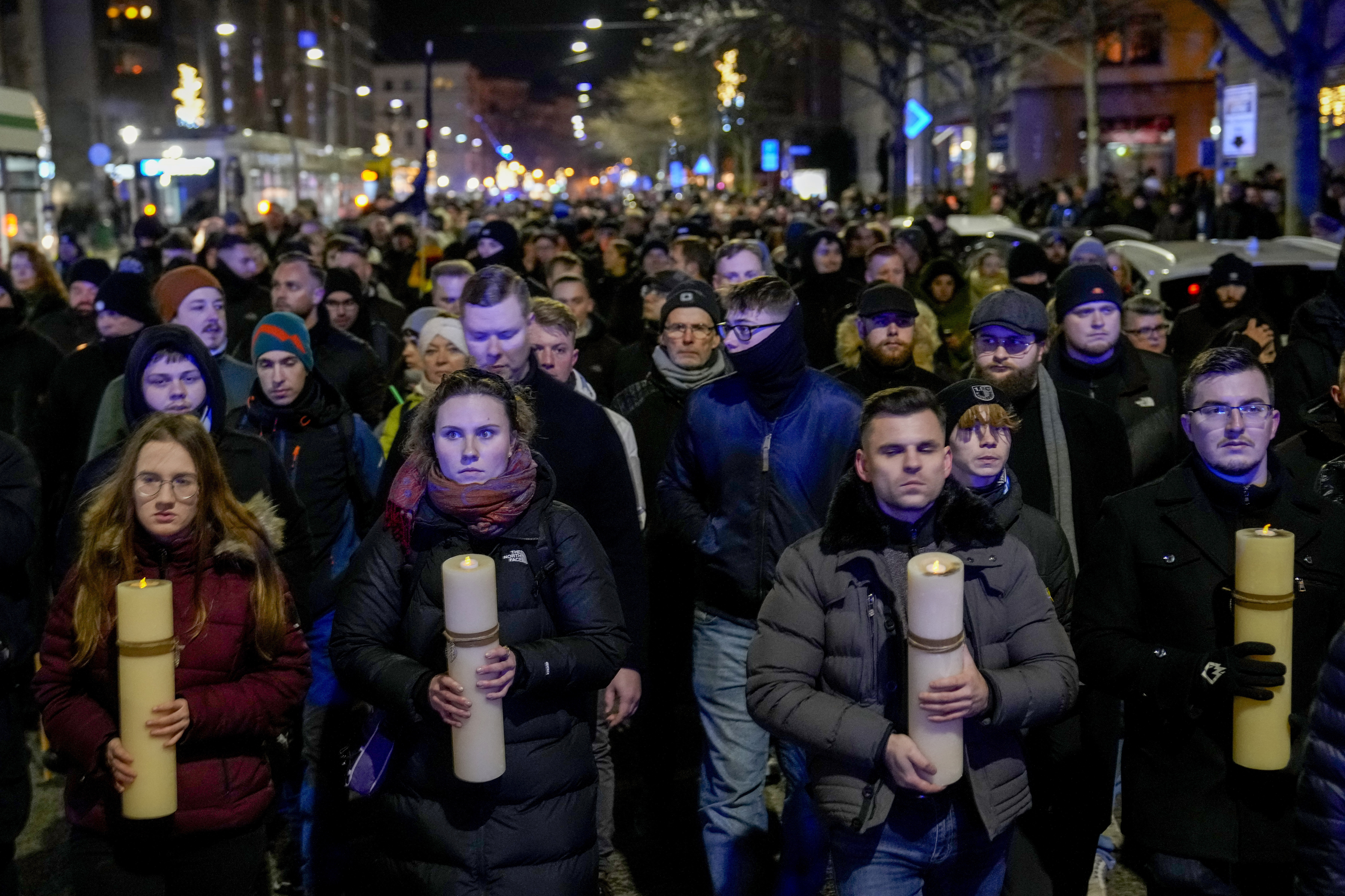 FILE - People carry candles attending an AfD election campaign in front of the cathedral in Magdeburg, Germany, on Dec. 23, 2024. (AP Photo/Ebrahim Noroozi, File)