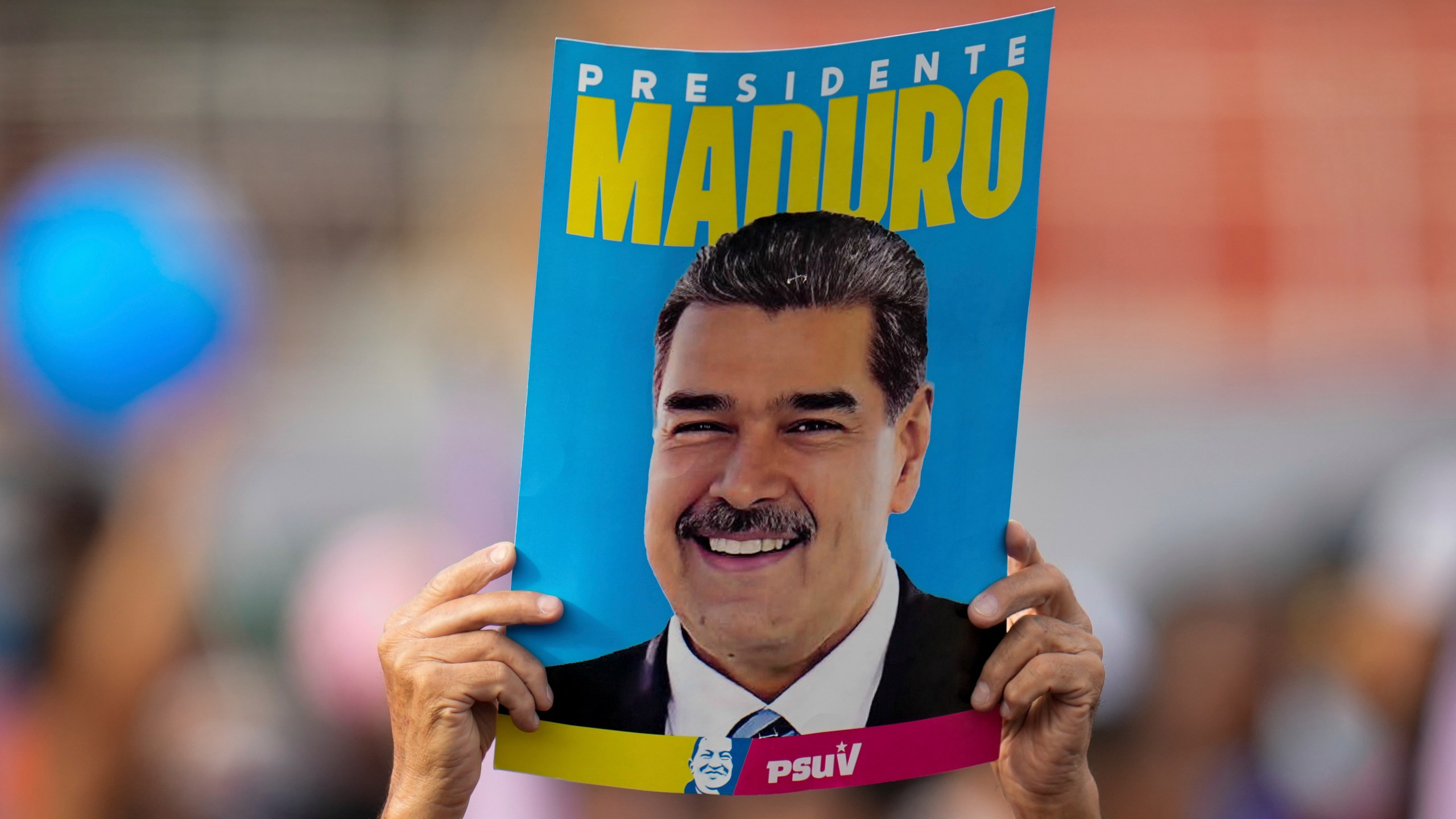 FILE - A supporter displays a poster of President Nicolas Maduro during his closing election campaign rally in Caracas, Venezuela, July 25, 2024. (AP Photo/Fernando Vergara, File)