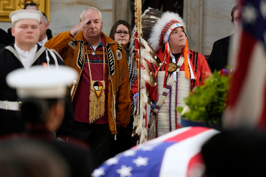 Army veteran Donald Woody, left, and Marine veteran Warren Stade, in eagle feather bonnet, pay their respects as former President Jimmy Carter lies in state at the U.S. Capitol, Wednesday, Jan. 8, 2025, in Washington. Carter died Dec. 29 at the age of 100. The two are from the Skakopee Mdewakanton Sioux Community in Prior Lake, Minn. (AP Photo/Steve Helber)