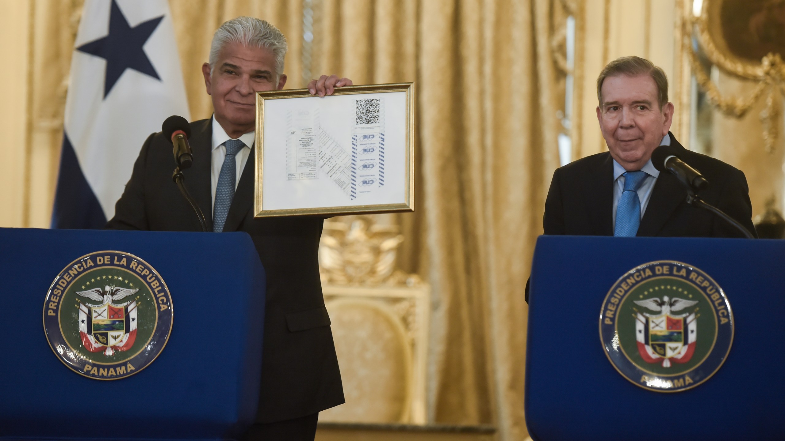 Panamanian President Jose Raul Mulino, left, holds up a copy of Venezuela's 2024 election tallies, given to him by Venezuela's opposition leader Edmundo Gonzalez Urrutia, right, at the presidential palace in Panama City, Wednesday, Jan. 8, 2025. (AP Photo/Agustin Herrera)