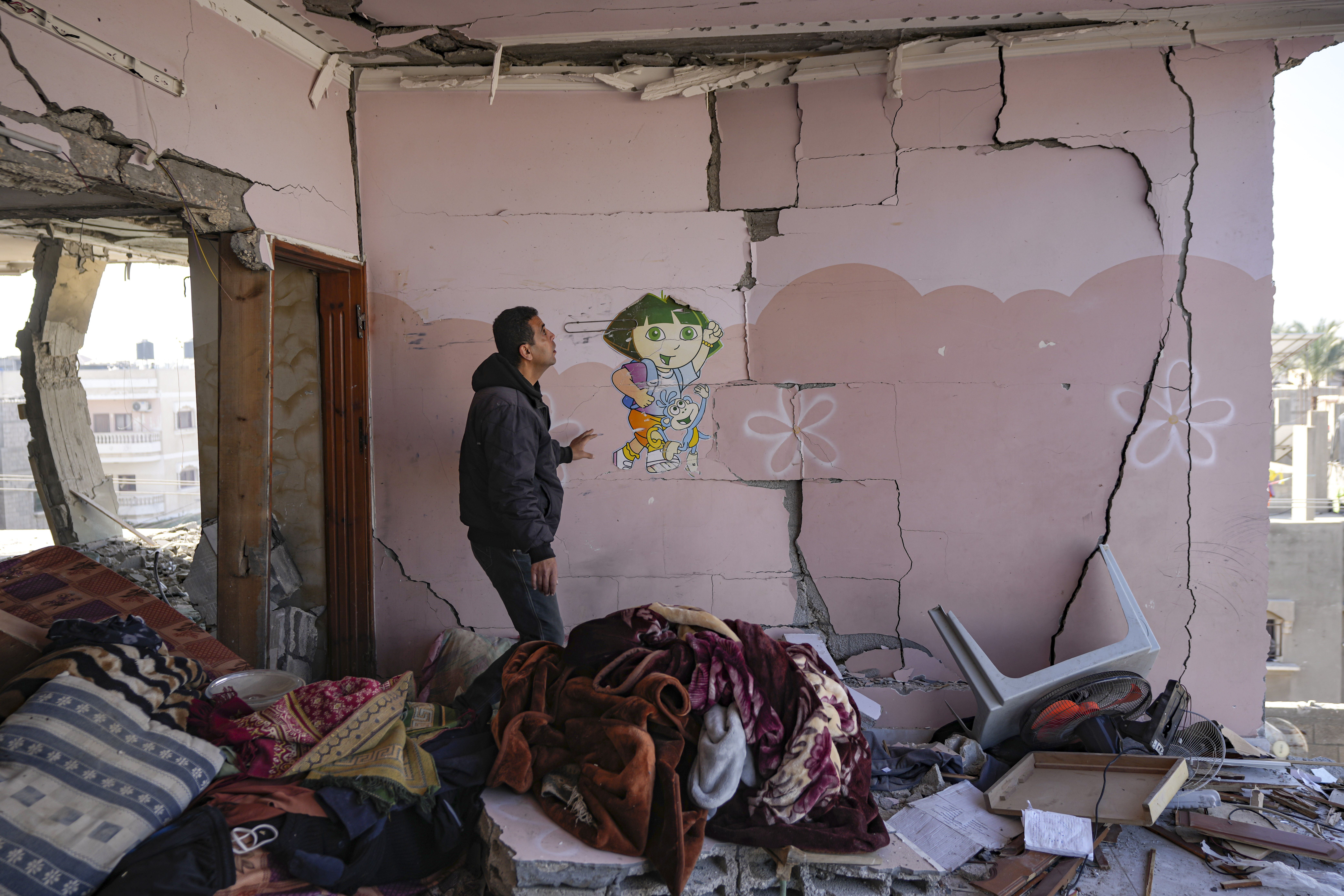 A Palestinian looks at a damaged residential building following an overnight Israeli strike in Deir al-Balah, Gaza Strip, Wednesday, Jan. 8, 2025. (AP Photo/Abdel Kareem Hana)