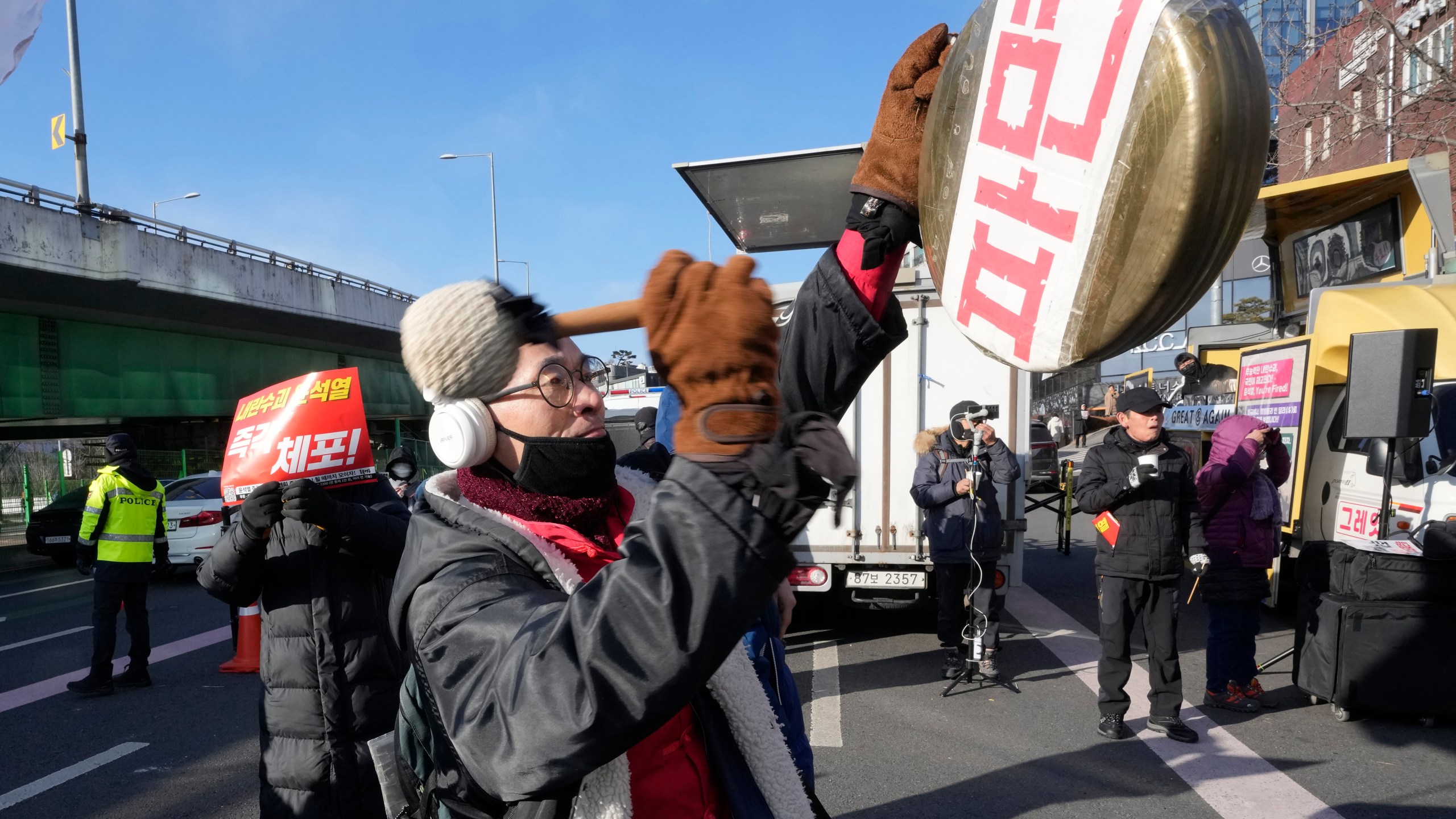 A protester beats a traditional Korean gong during a rally demanding the arrest of impeached South Korean President Yoon Suk Yeol near the presidential residence in Seoul, South Korea, Thursday, Jan. 9, 2025. The letters read "Dismiss." (AP Photo/Ahn Young-joon)