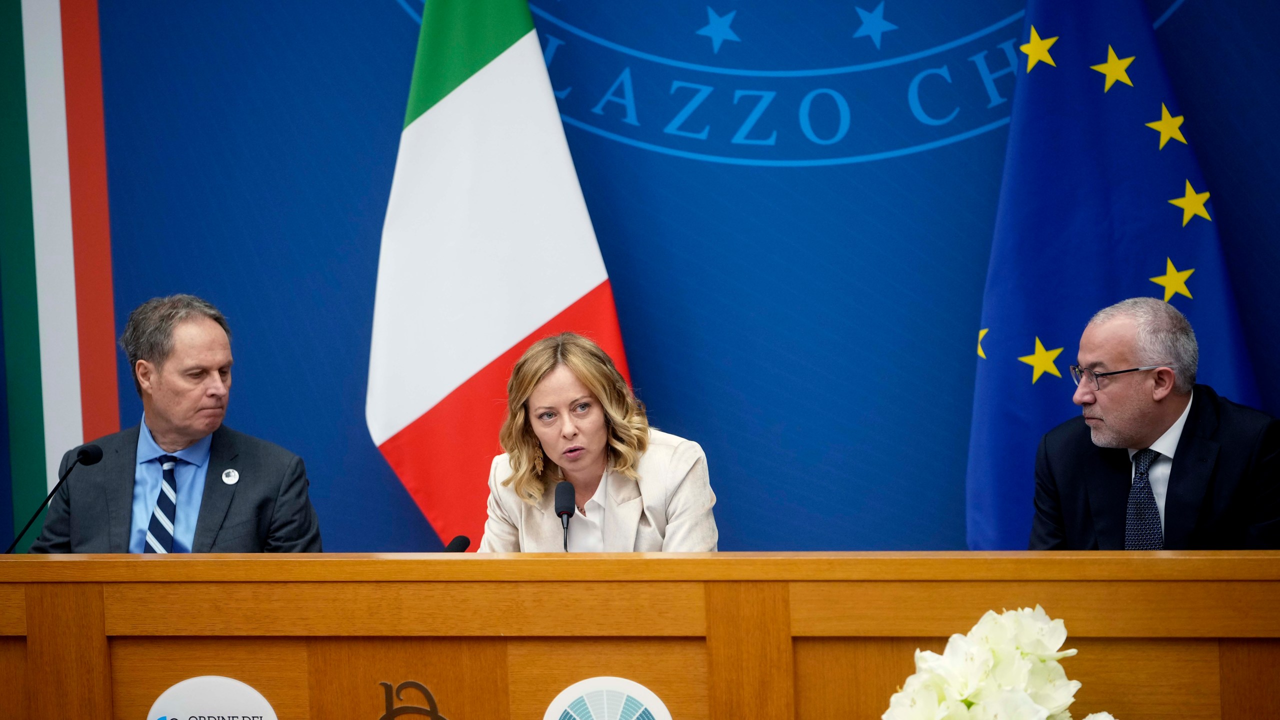 Italian Premier Giorgia Meloni holds the 2024 year-end press conference, flanked by the Italian president of the Order of Journalists, Carlo Bartoli, left, and Italian national press federation president Vittorio Di Trapani, in Rome, Thursday, Jan. 9, 2025. (AP Photo/Alessandra Tarantino)