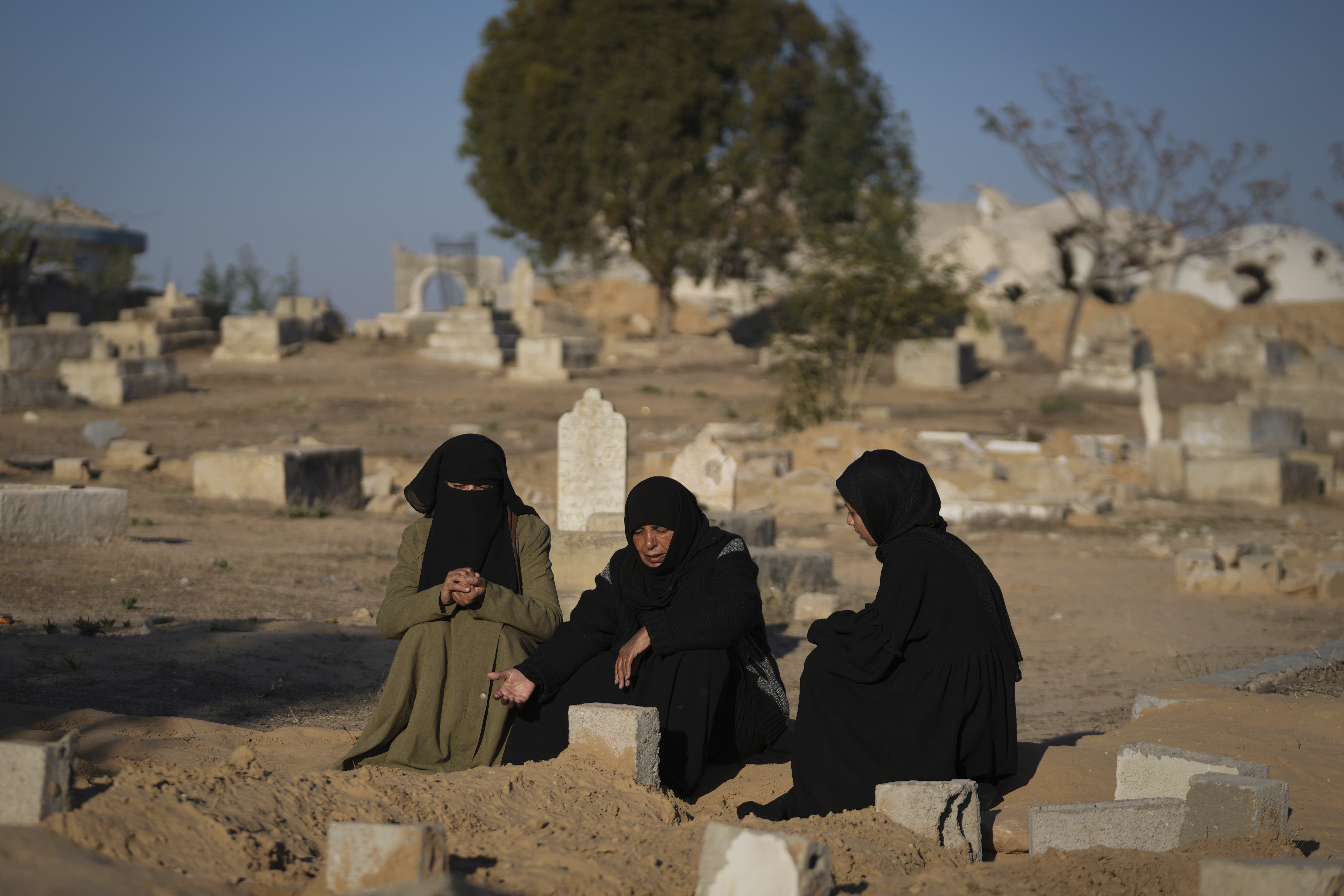 Fatma Abu Awad and her daughter Malak pray in a graveyard where their relatives who were killed by an Israeli airstrike are buried, in Khan Younis, Gaza, Thursday, Jan. 9, 2025. (AP Photo/Abdel Kareem Hana)