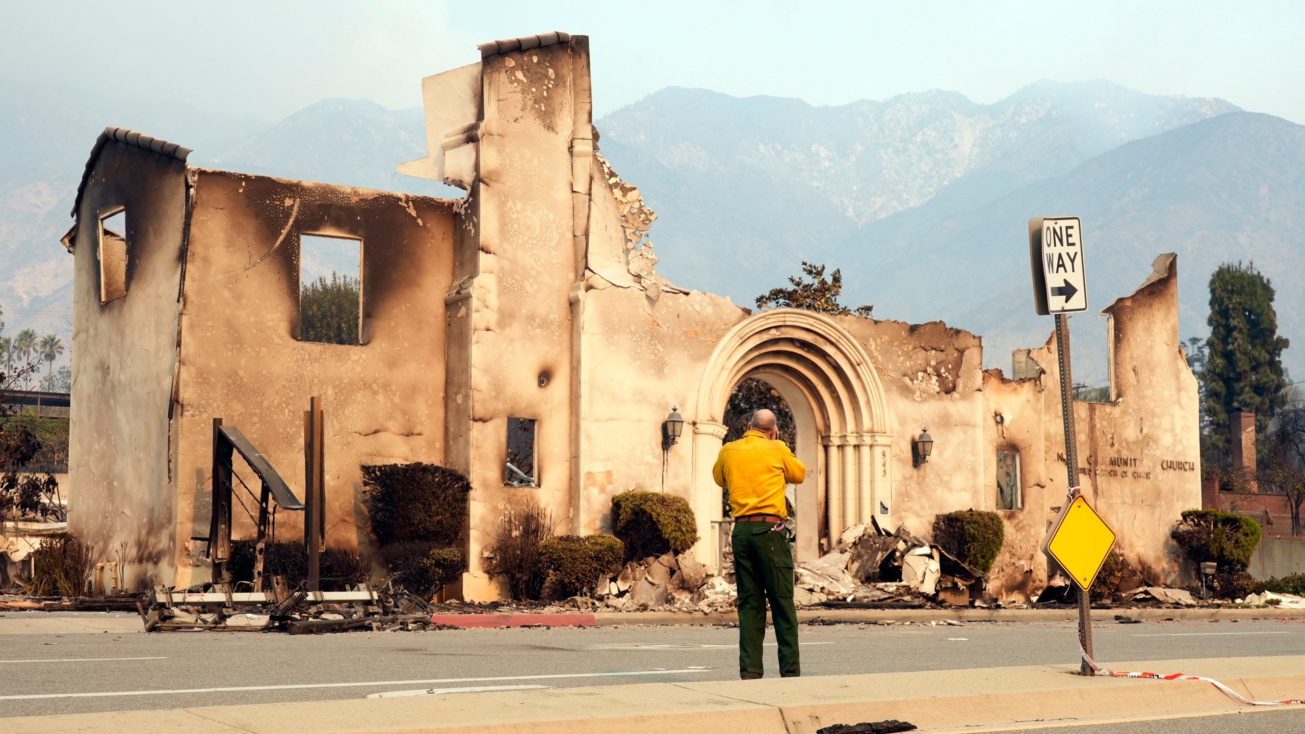 A man photographs the destroyed Altadena Community Church, Thursday, Jan. 9, 2025, in the Altadena section of Pasadena, Calif. (AP Photo/Chris Pizzello)