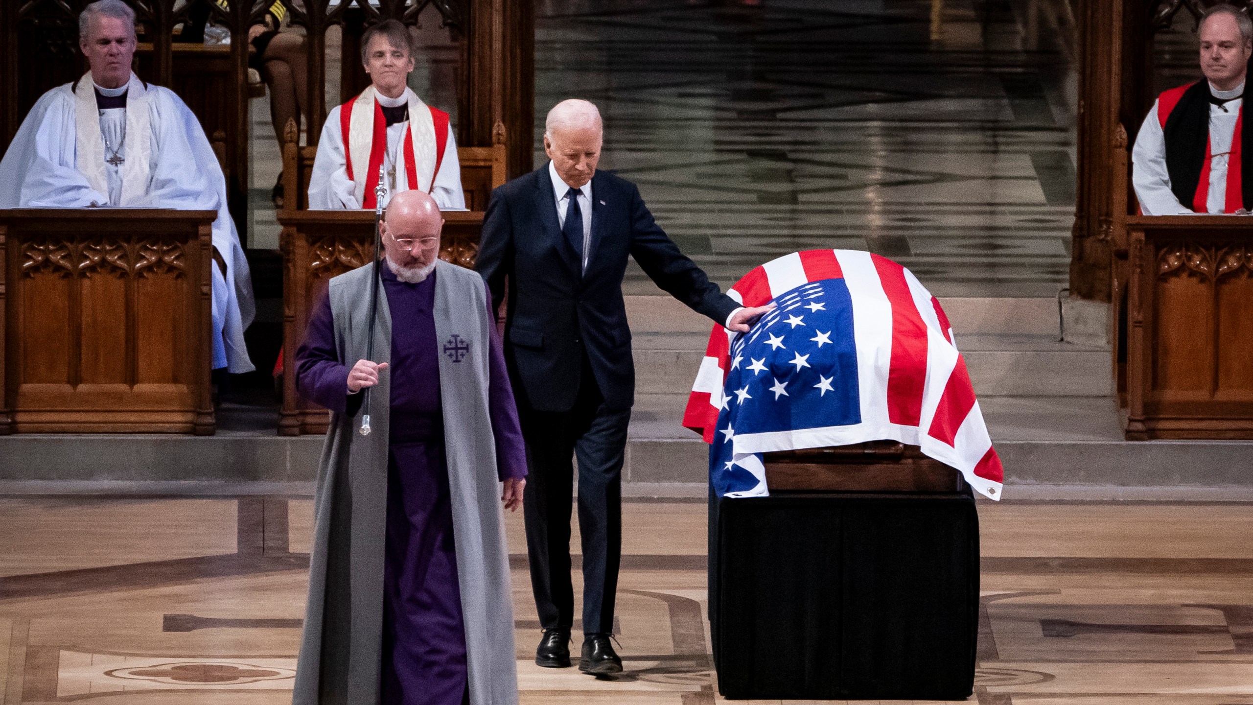 President Joe Biden touches the casket of former President Jimmy Carter after delivering remarks during Carter's state funeral at the National Cathedral, Thursday, Jan. 9, 2025, in Washington. (Haiyun Jiang/The New York Times via AP, Pool)