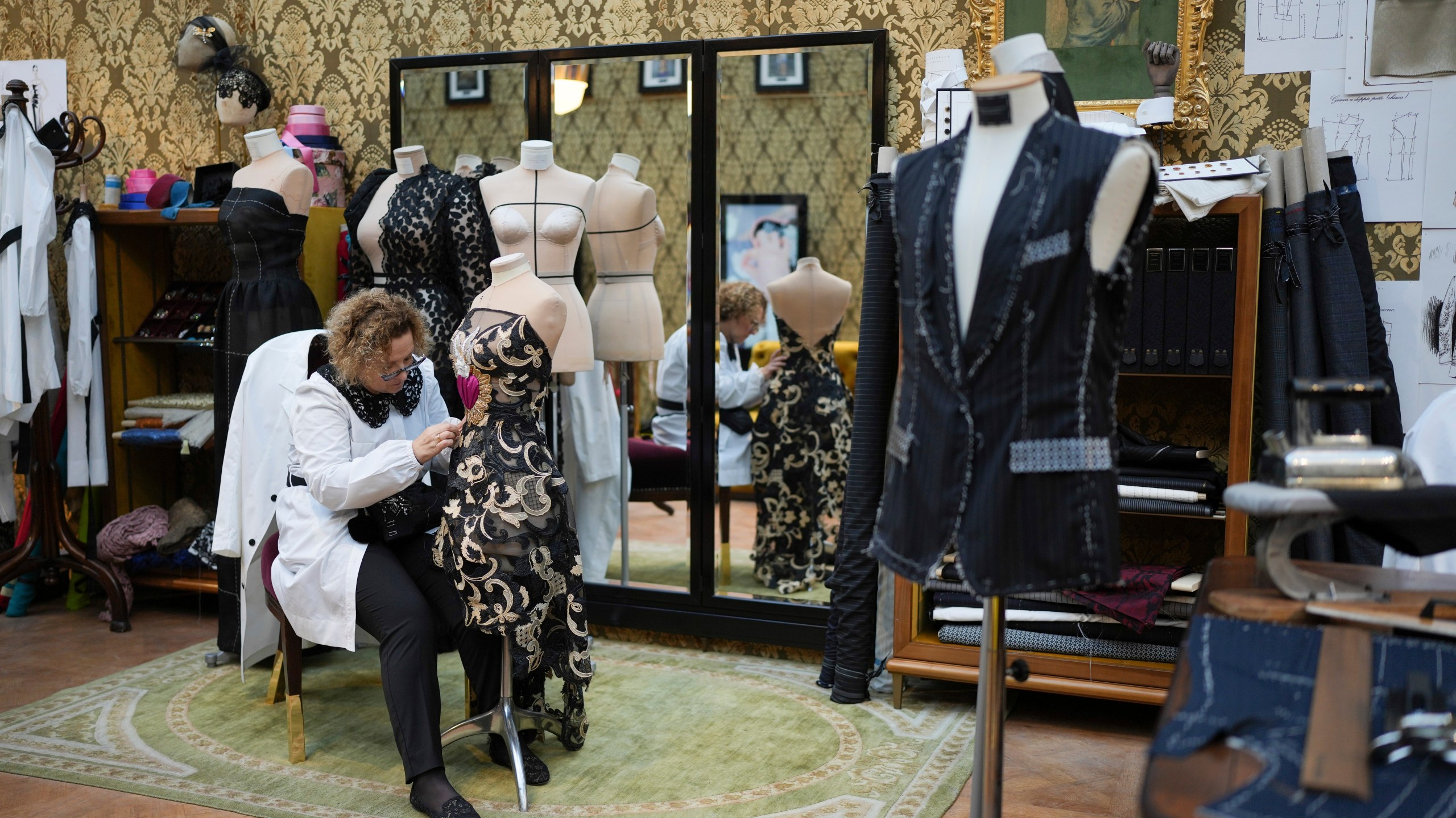 A seamstress works on a dress during the exhibition "From the Heart to the Hands: Dolce&Gabbana" at the Grand Palais, in Paris, Thursday, Jan. 9, 2025. (AP Photo/Thibault Camus)