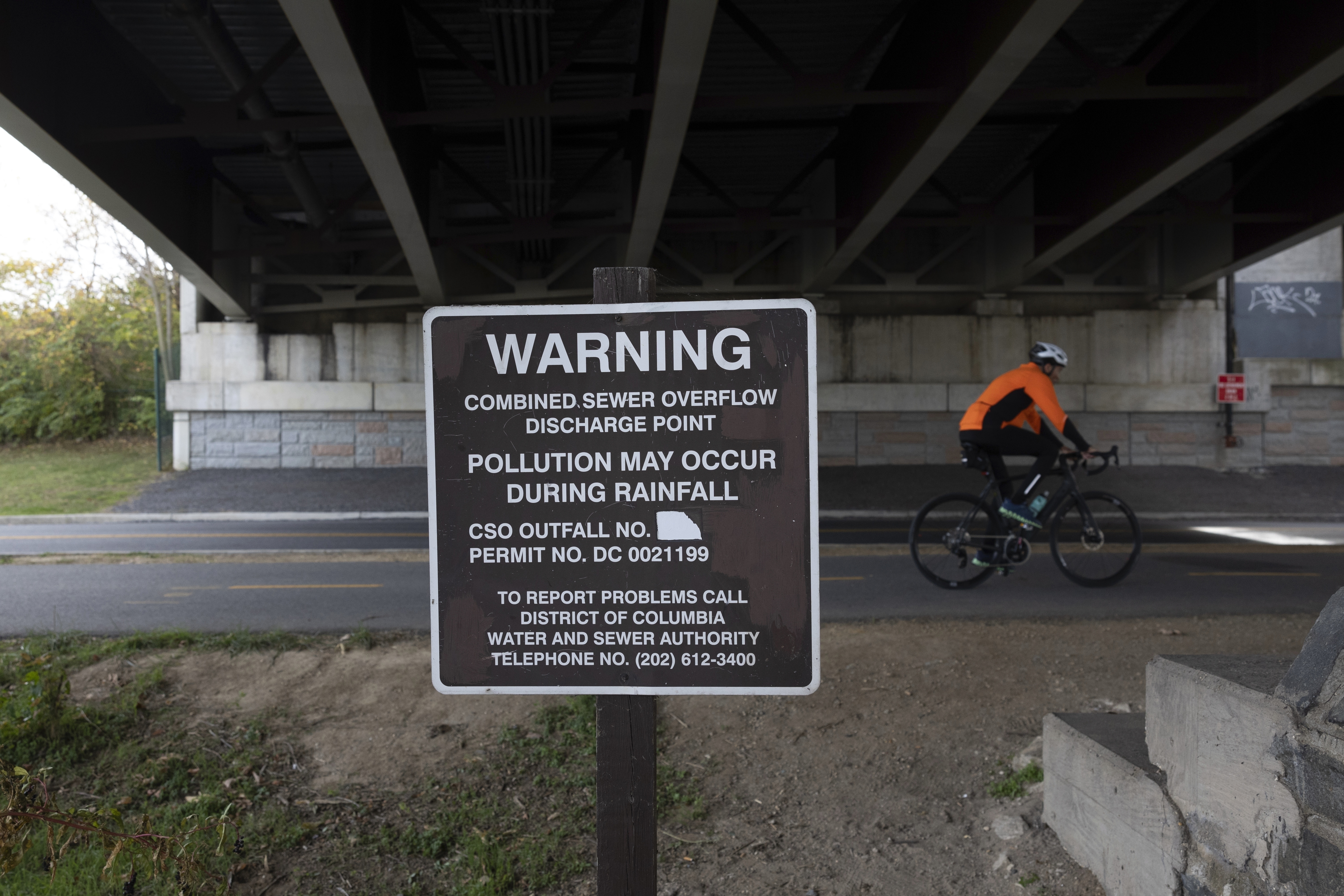 FILE - A bicyclist rides along a shoreline paved trail on Wednesday, Nov. 15, 2023, at Anacostia Park in Washington. (AP Photo/Tom Brenner, File)