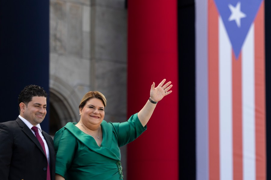 Jenniffer Gonzalez Colon waves alongside her husband Jose Yovin Vargas during her swearing-in ceremony as governor outside the Capitol in San Juan, Puerto Rico, Thursday, Jan. 2, 2025. (AP Photo/Alejandro Granadillo)