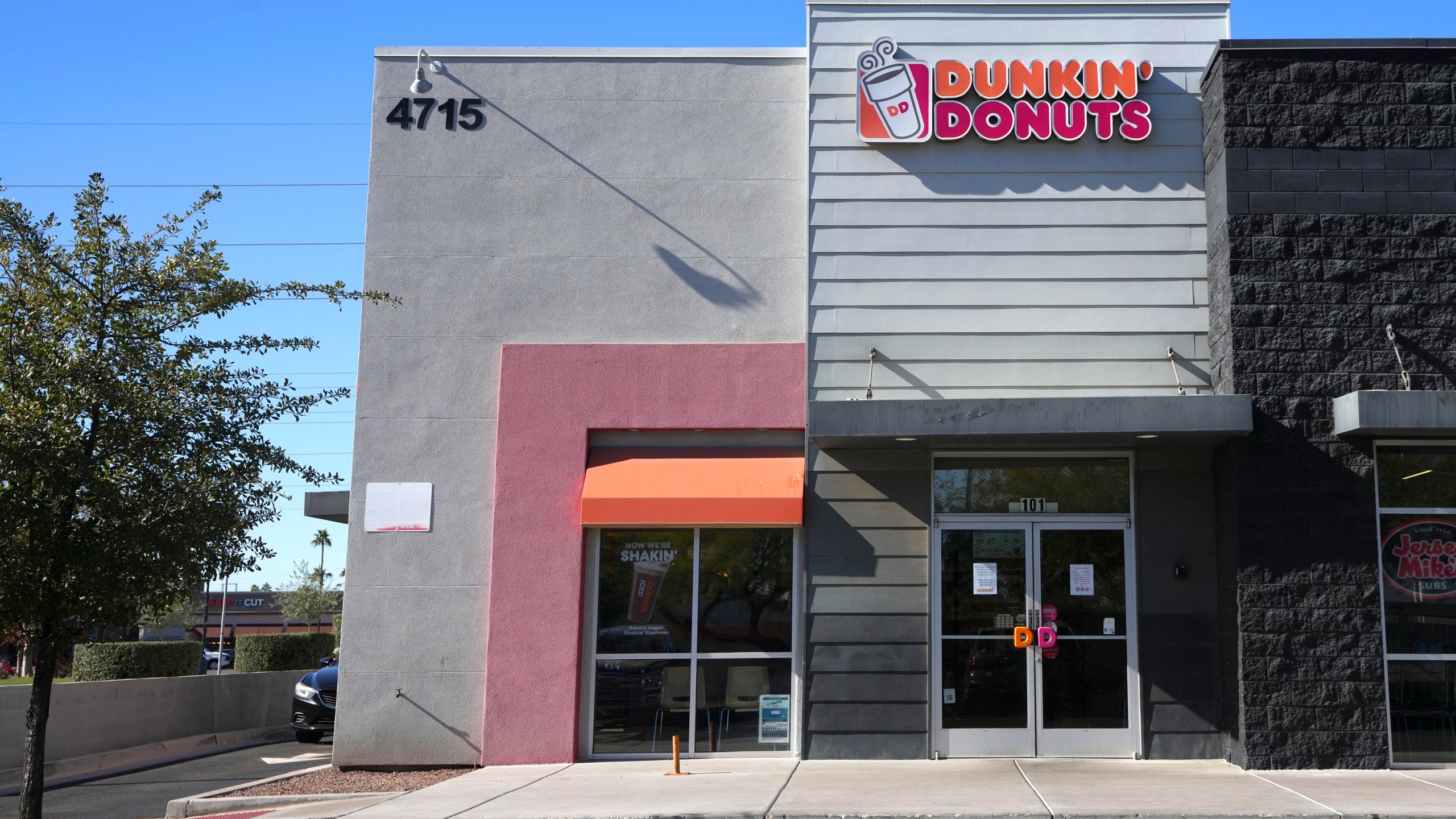 Signs on the doors of a Dunkin' Donuts restaurant explains that customers will find limited doughnut selections for sale Friday, Jan. 10, 2025, in Tempe, Ariz. (AP Photo/Ross D. Franklin)