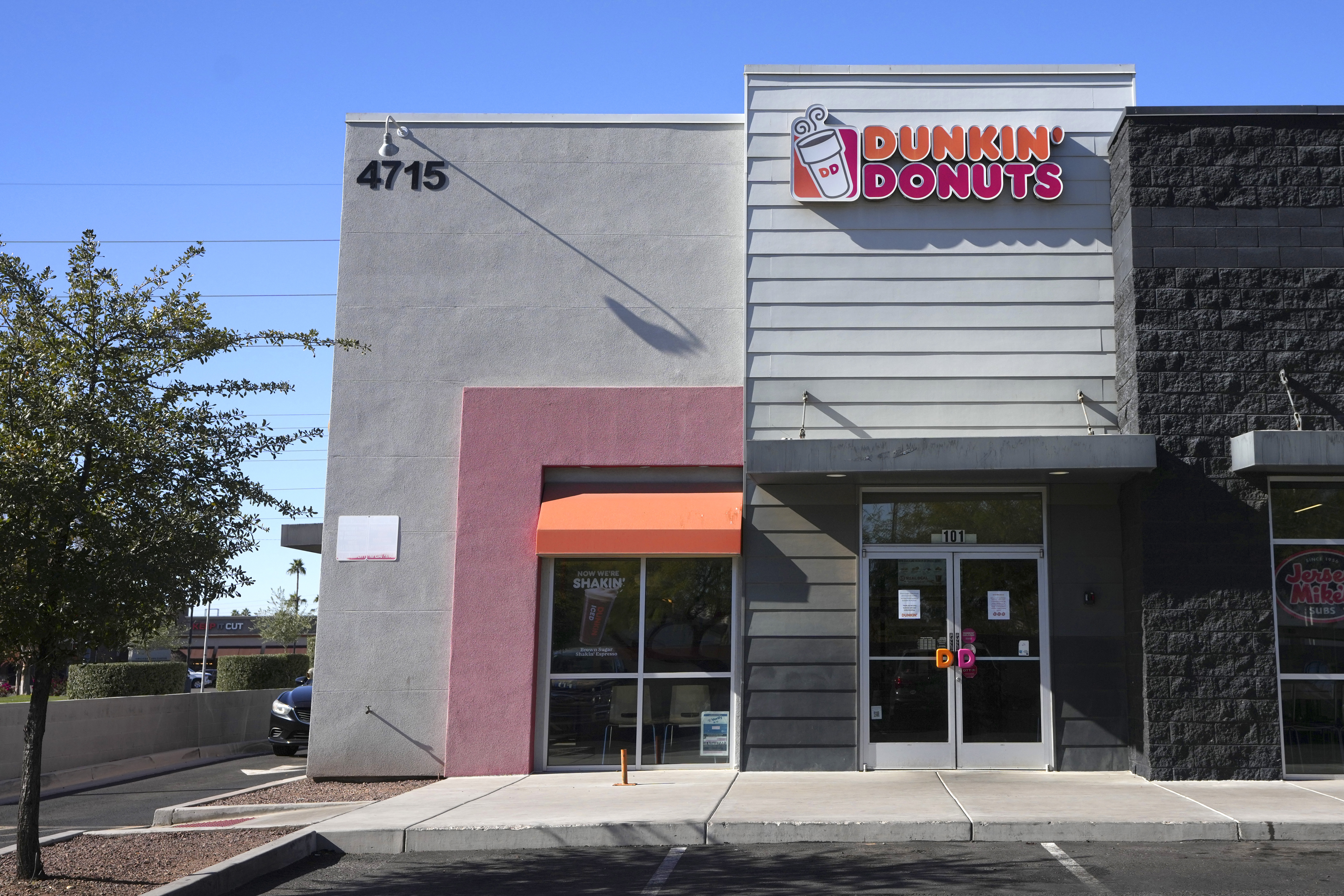 Signs on the doors of a Dunkin' Donuts restaurant explains that customers will find limited doughnut selections for sale Friday, Jan. 10, 2025, in Tempe, Ariz. (AP Photo/Ross D. Franklin)