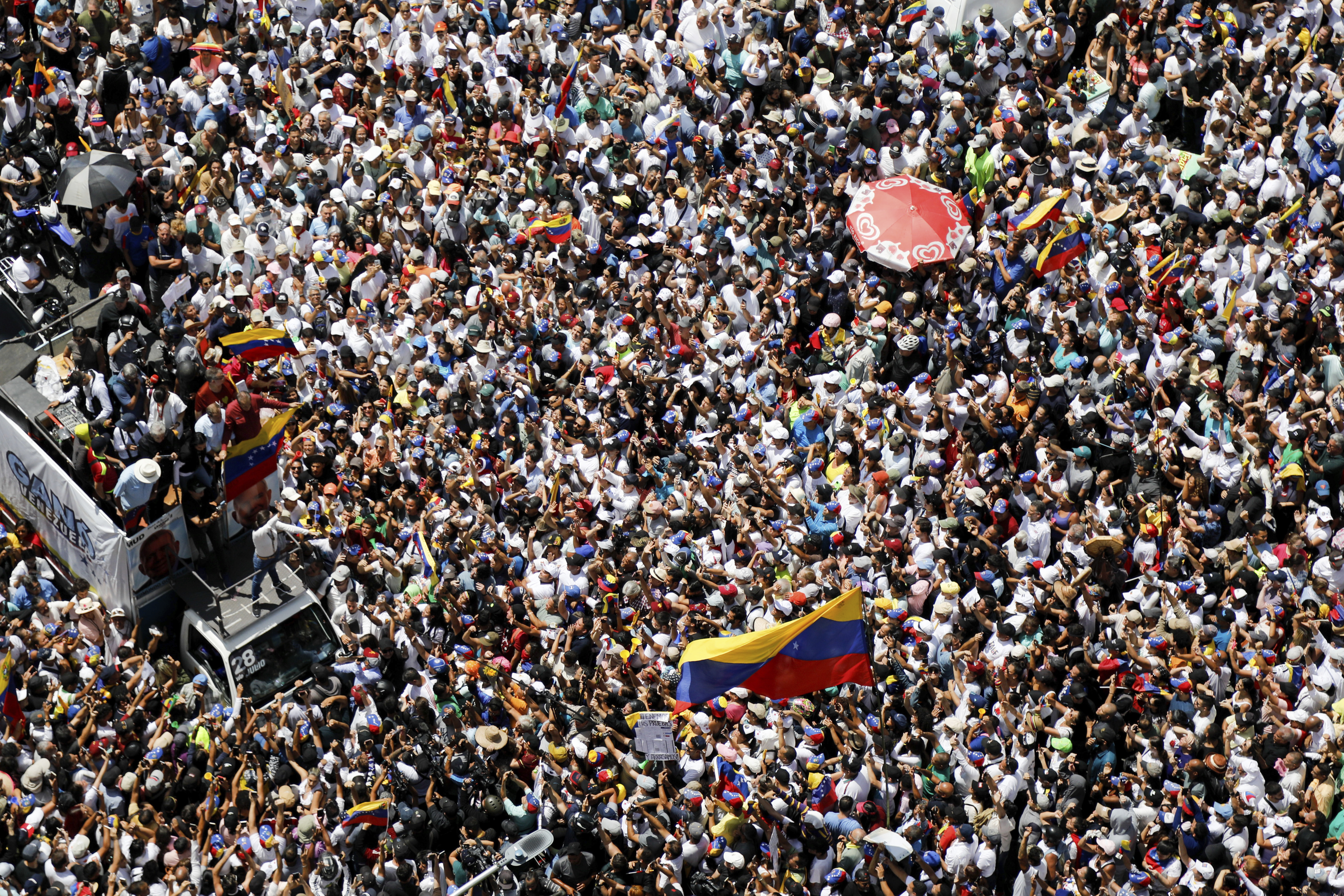 FILE - Opposition leader Maria Corina Machado, lower right, waves a Venezuelan national flag, during a rally to protest official results that declared President Nicolas Maduro the winner of the July presidential election, in Caracas, Venezuela, Aug. 17, 2024. (AP Photo/Cristian Hernandez, File)