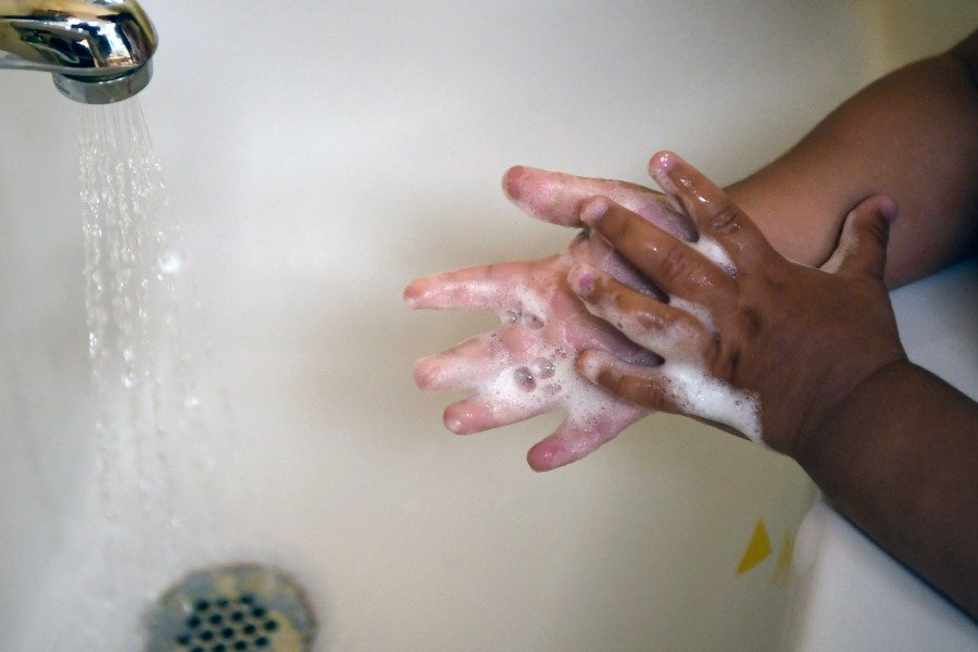 FILE - A child washes her hands at a day care center in Connecticut on Thursday Aug. 27, 2020. (AP Photo/Jessica Hill, File)