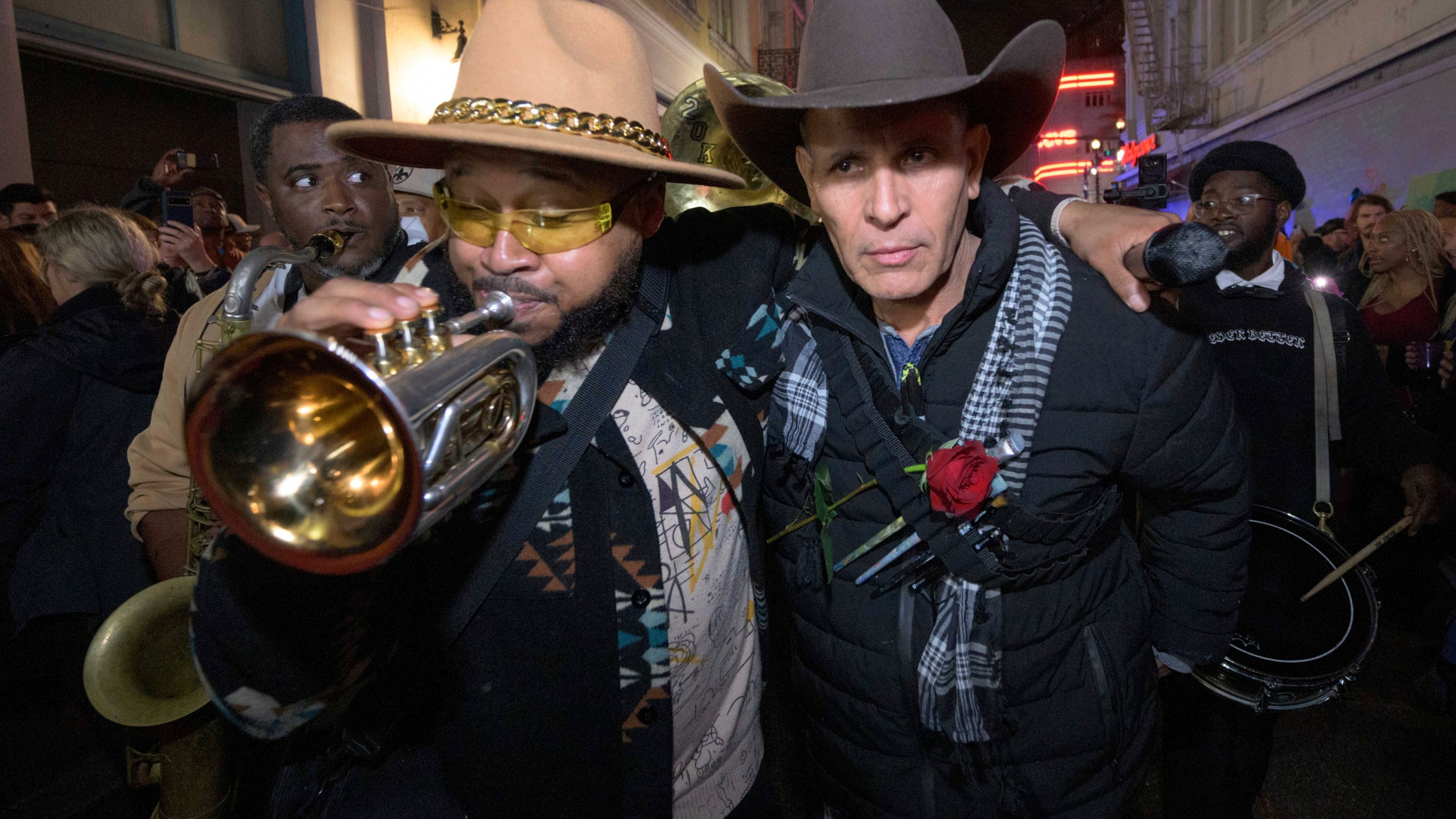 Amir "Tubad" Gray, left, leads Tubad and the Kings of NOLA Brass Band and artist Roberto Marquez, right, in New Orleans, Saturday, Jan. 4, 2025, as they memorialize the victims of the New Year's Day deadly truck attack and shooting. Marquez organized the parade and vigil and designed a memorial for the victims on Bourbon Street. (AP Photo/Matthew Hinton)