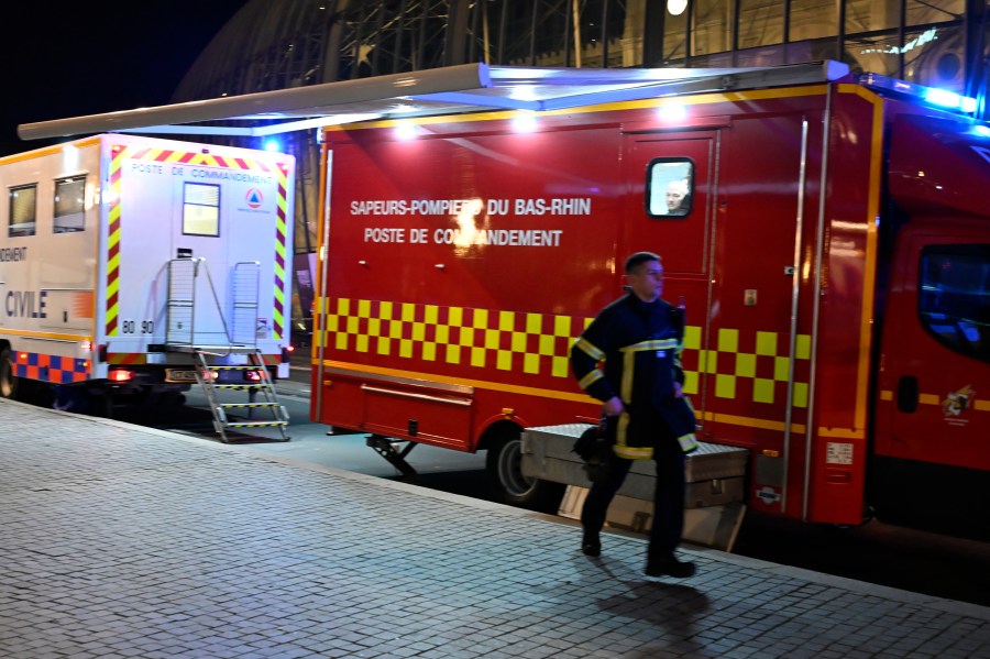 A firefighter rushes to the train station after two trams collided, injuring dozens of people, though none critically, firefighters said, Saturday, Jan. 11, 2025 in Strasbourg, eastern France. (AP Photo/Pascal Bastien)