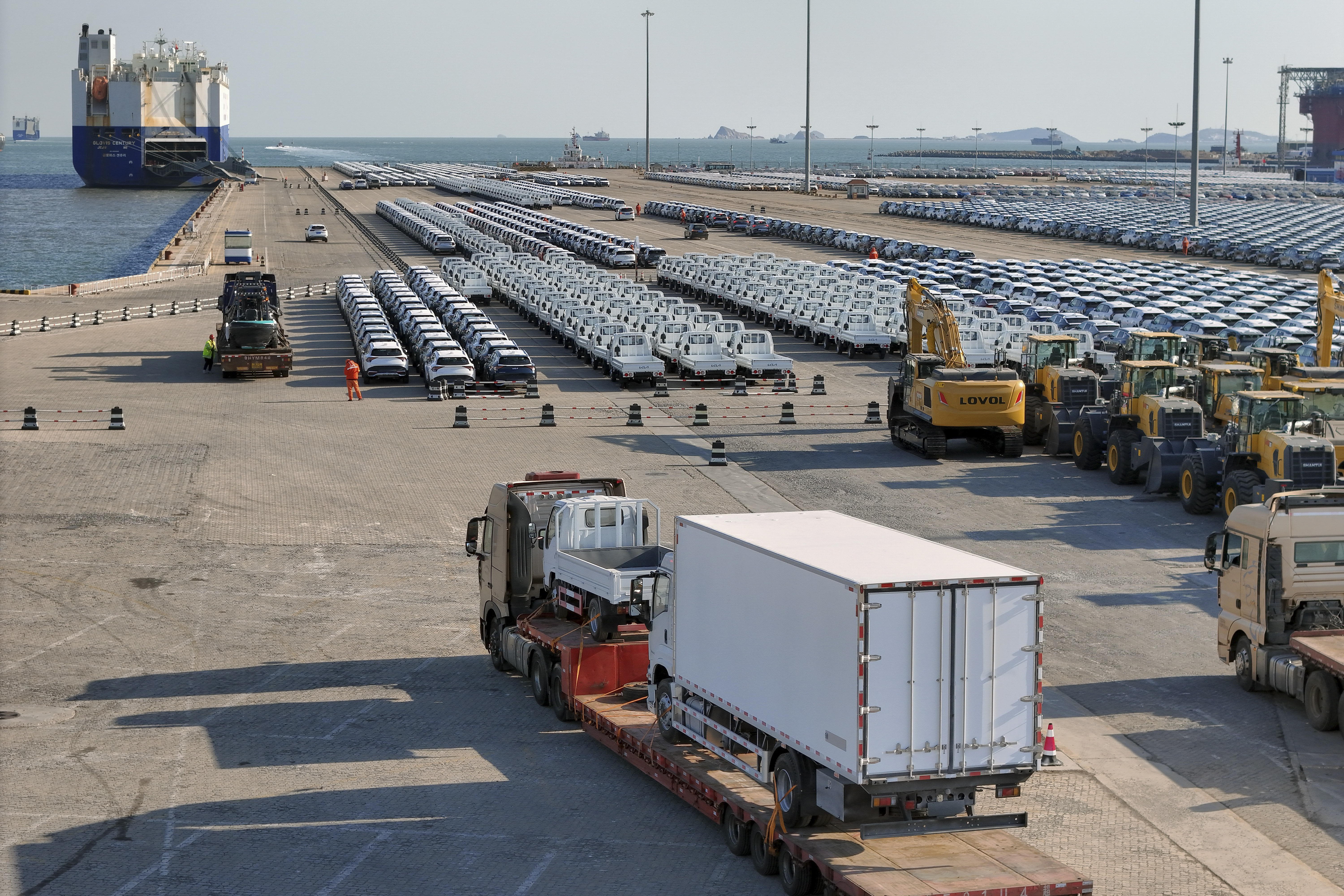 A truck loaded with vehicles moves to lines of vehicles for export at a port in Yantai in eastern China's Shandong province on Jan. 2, 2025. (Chinatopix via AP)