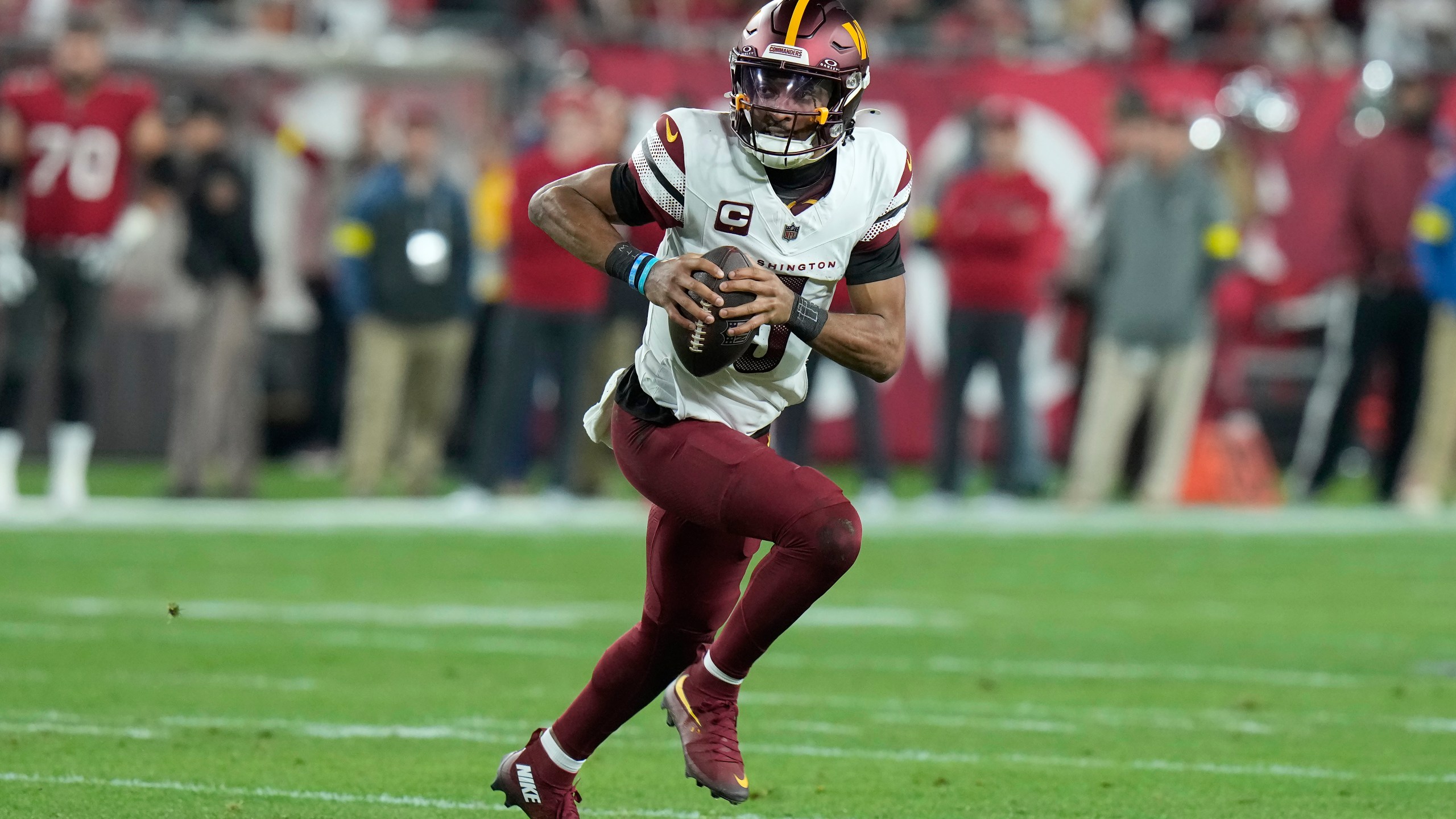 Washington Commanders quarterback Jayden Daniels (5) scrambles out of the pocket against the Tampa Bay Buccaneers during the first half of an NFL wild-card playoff football game in Tampa, Fla., Sunday, Jan. 12, 2025. (AP Photo/Chris O'Meara)