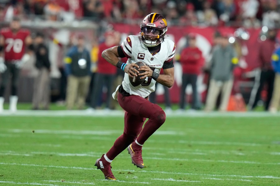 Washington Commanders quarterback Jayden Daniels (5) scrambles out of the pocket against the Tampa Bay Buccaneers during the first half of an NFL wild-card playoff football game in Tampa, Fla., Sunday, Jan. 12, 2025. (AP Photo/Chris O'Meara)