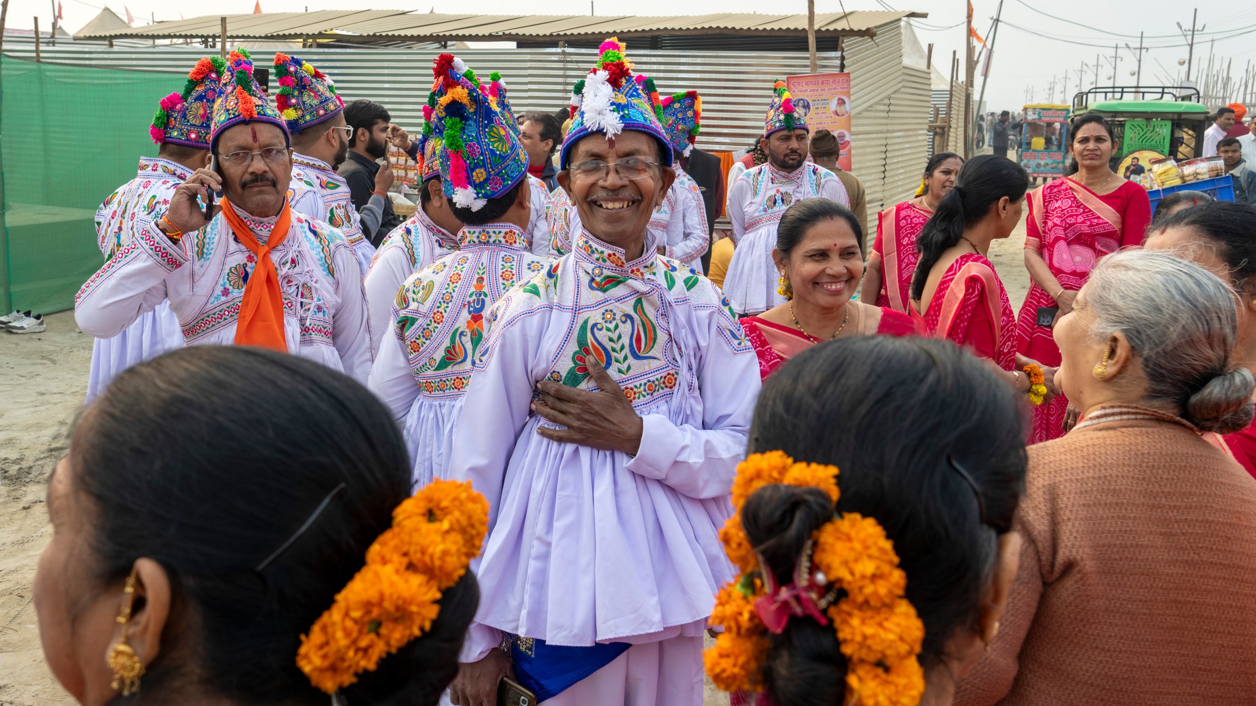 Hindu devotees wearing the ceremonial costume of the Kathiawar region in Gujarat state, sing hymns at the confluence of the Ganges, the Yamuna and the mythical Saraswati rivers, a day before the official beginning of the 45-day-long Maha Kumbh festival, in Prayagraj, India, Sunday, Jan. 12, 2025. (AP Photo/Ashwini Bhatia)