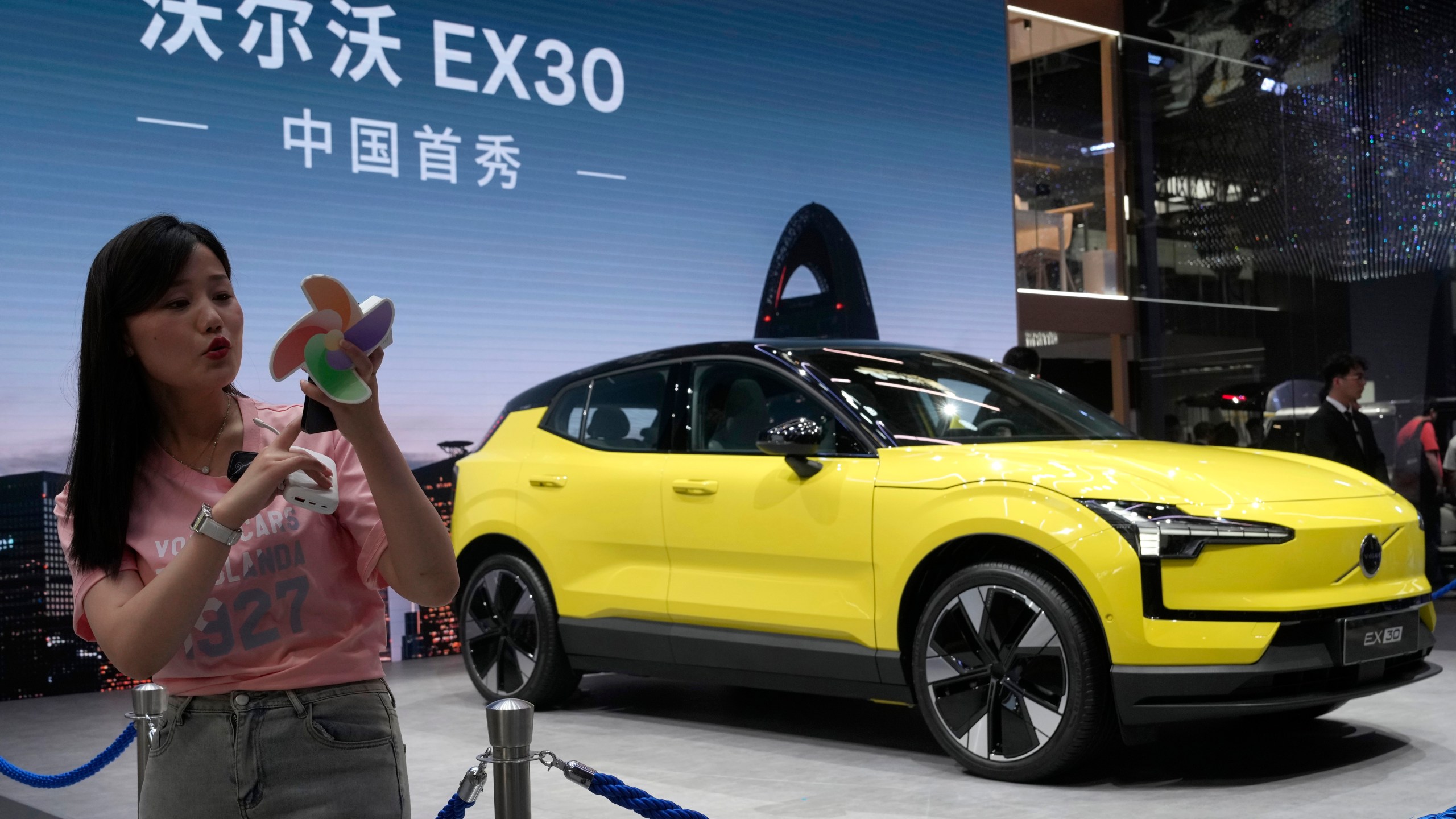 FILE - A live streamer works near the Volvo EX30 fully electric small SUV unveiled during Auto China 2024 in Beijing, Thursday, April 25, 2024. (AP Photo/Ng Han Guan, File)