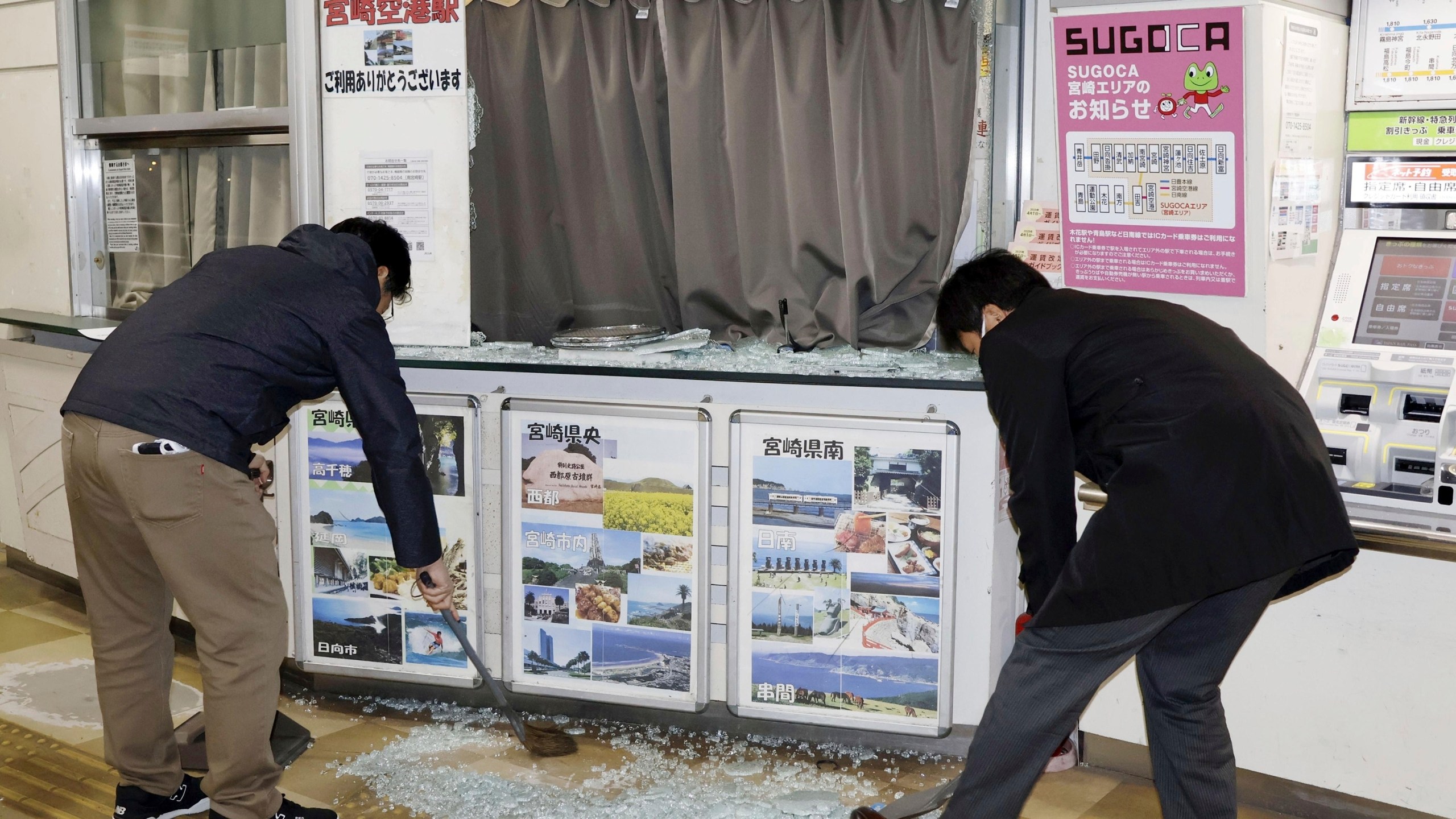 Staff clean up shattered and scattered glass caused by the earthquake at JR Miyazaki Airport Station, in Miyazaki, in southwestern Japan, Monday Jan. 13, 2025. (Kyodo News via AP)