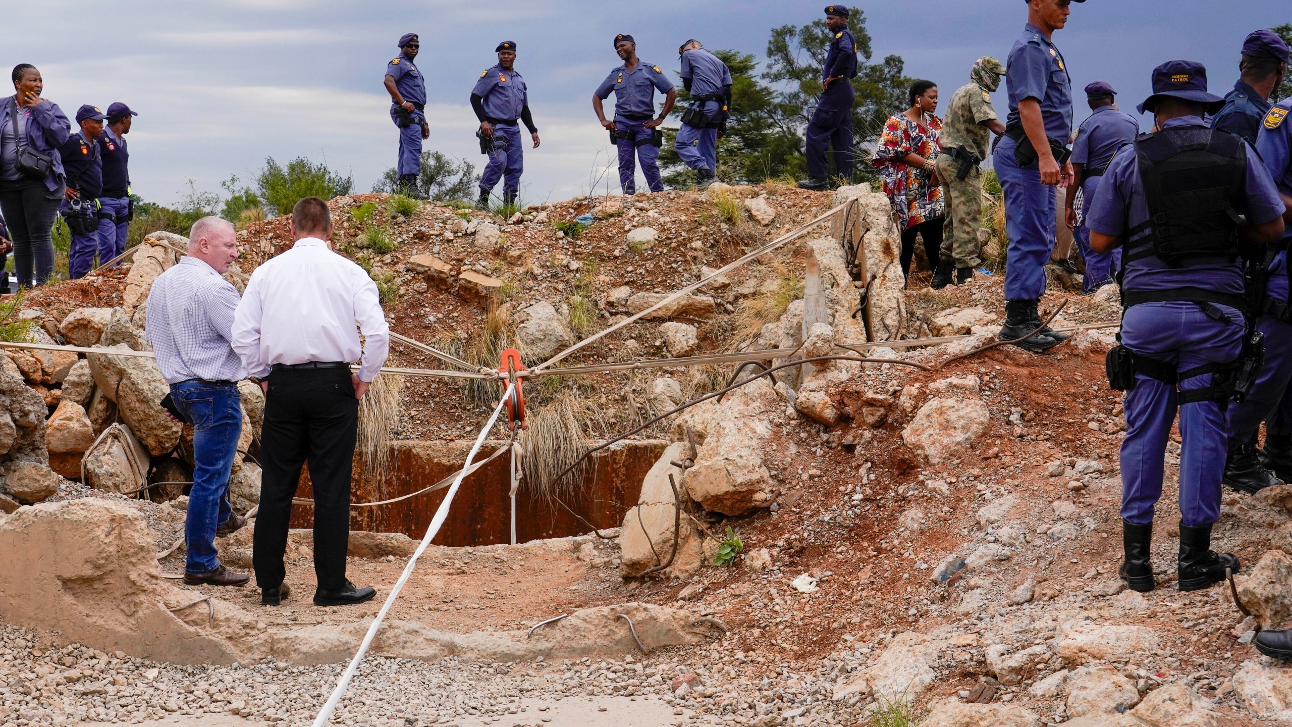 FILE - Police officers and private security personnel stand by the opening of a reformed gold mineshaft where illegal miners are trapped in Stilfontein, South Africa, Friday, Nov.15, 2024. (AP Photo/Denis Farrell, File)