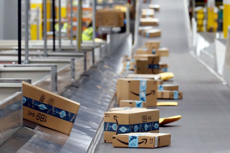 FILE - Amazon packages move along a conveyor at an Amazon warehouse facility, Dec. 17, 2019, in Goodyear, Ariz. (AP Photo/Ross D. Franklin, File)