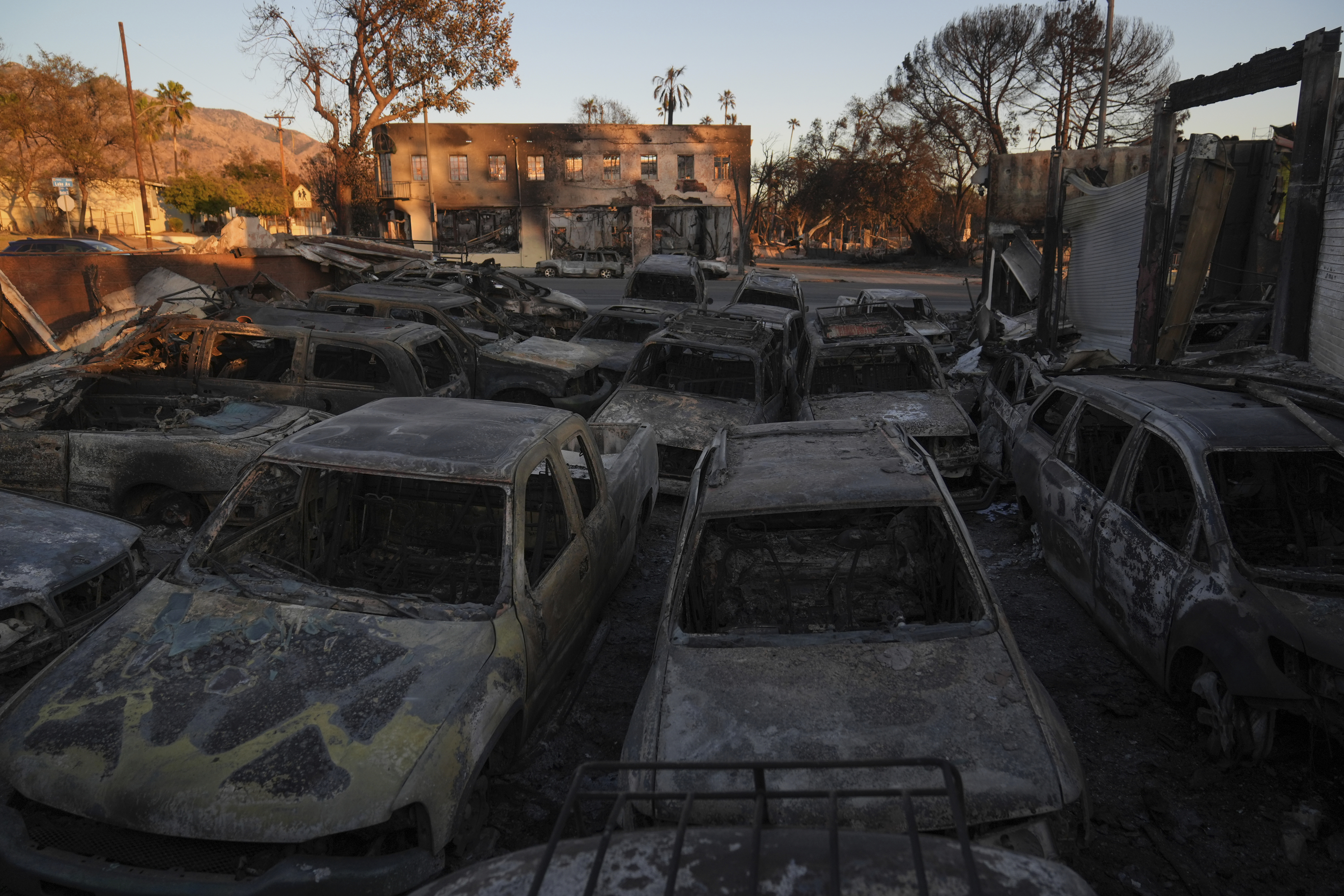 Cars sit at an auto repair shop after they were destroyed by the Eaton Fire in Altadena, Calif., Monday, Jan. 13, 2025. (AP Photo/Jae C. Hong)