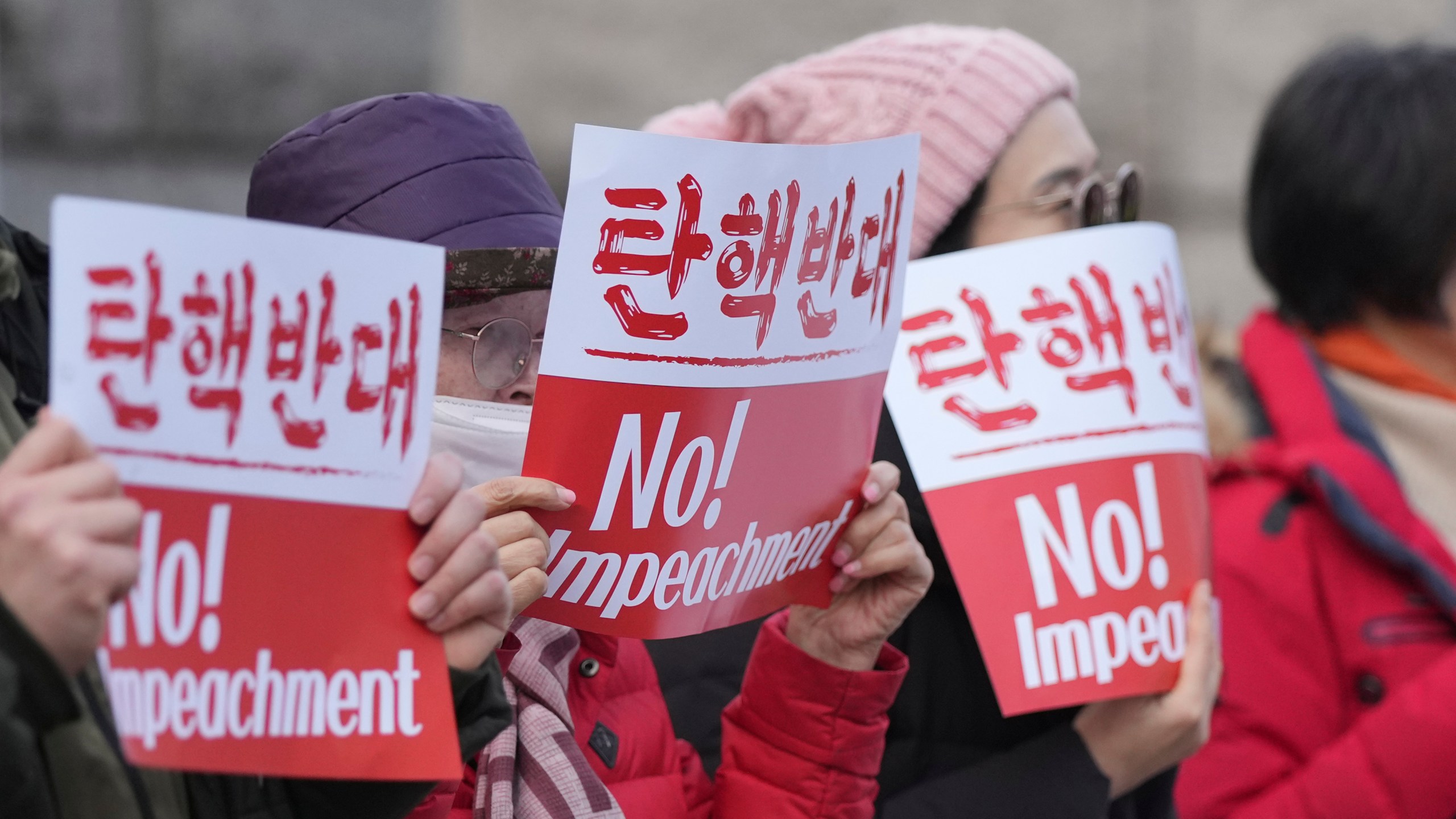 Supporters of impeached South Korean President Yoon Suk Yeol hold signs during a rally to oppose his impeachment outside the Constitutional Court in Seoul, South Korea, Tuesday, Jan. 14, 2025. (AP Photo/Lee Jin-man)