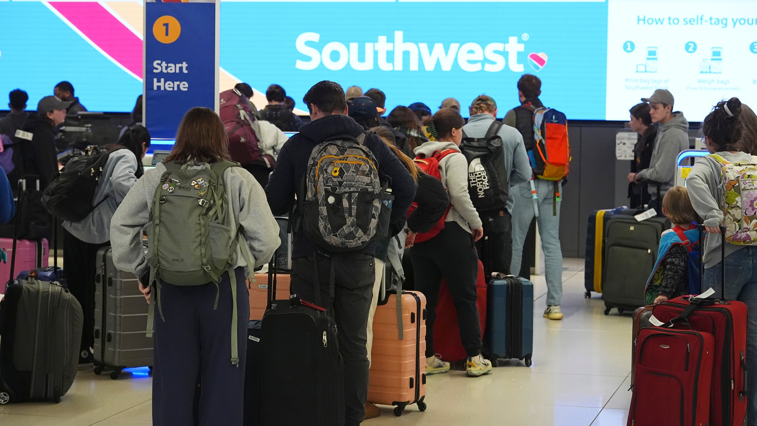 Travelers wait at the check-in counter for Southwest Airlines in Denver International Airport Thursday, Dec. 19, 2024, in Denver. (AP Photo/David Zalubowski)