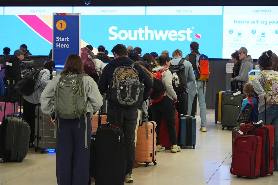 Travelers wait at the check-in counter for Southwest Airlines in Denver International Airport Thursday, Dec. 19, 2024, in Denver. (AP Photo/David Zalubowski)