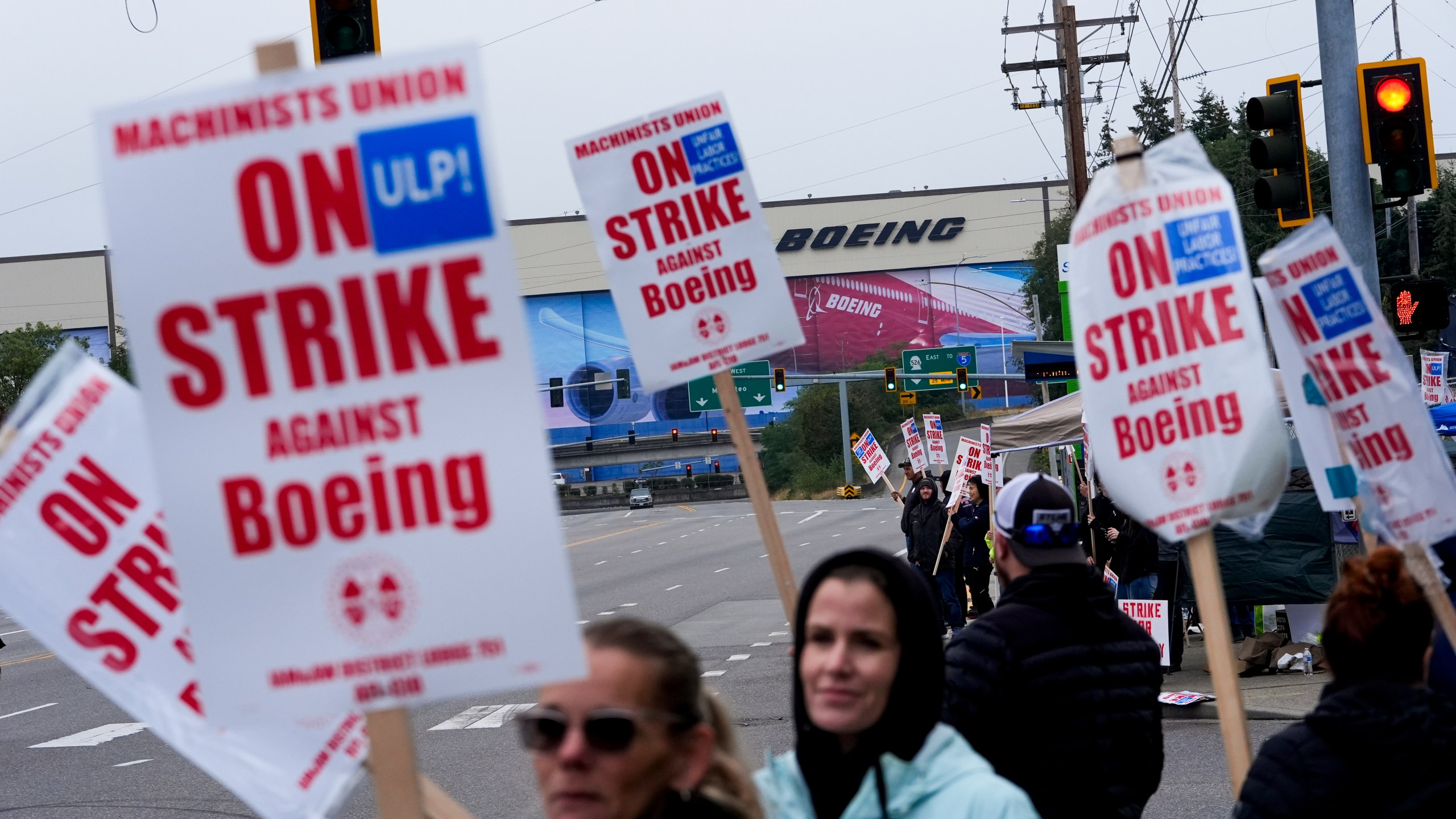 FILE - Boeing workers wave picket signs as they strike after union members voted to reject a contract offer near the company's factory in Everett, Washington, Sept. 15, 2024. (AP Photo/Lindsey Wasson)