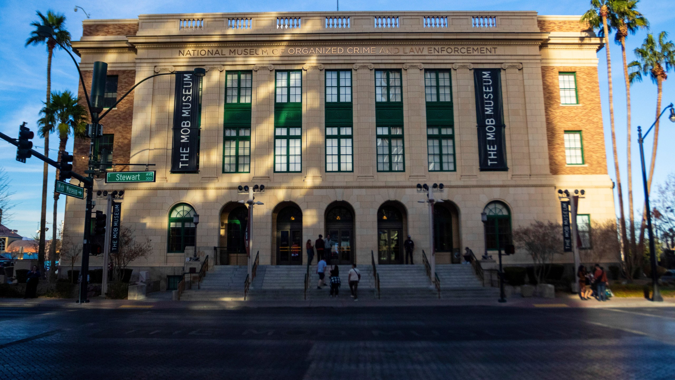 People walk into the Mob Museum in Las Vegas, Monday, Dec. 23, 2024, where a new exhibit, "The First Public Enemy," featuring Al Capone's favorite personal weapon and a snippet of a film he shot at his Miami mansion, opens Jan. 15, 2025. (AP Photo/Ty ONeil)