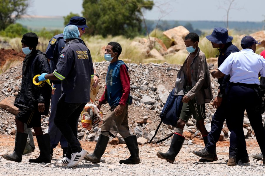 Illegal miners are escorted by police officers after being rescued from an abandoned gold mine for months, in Stilfontein, South Africa, Tuesday, Jan. 14, 2025. (AP Photo/Themba Hadebe)