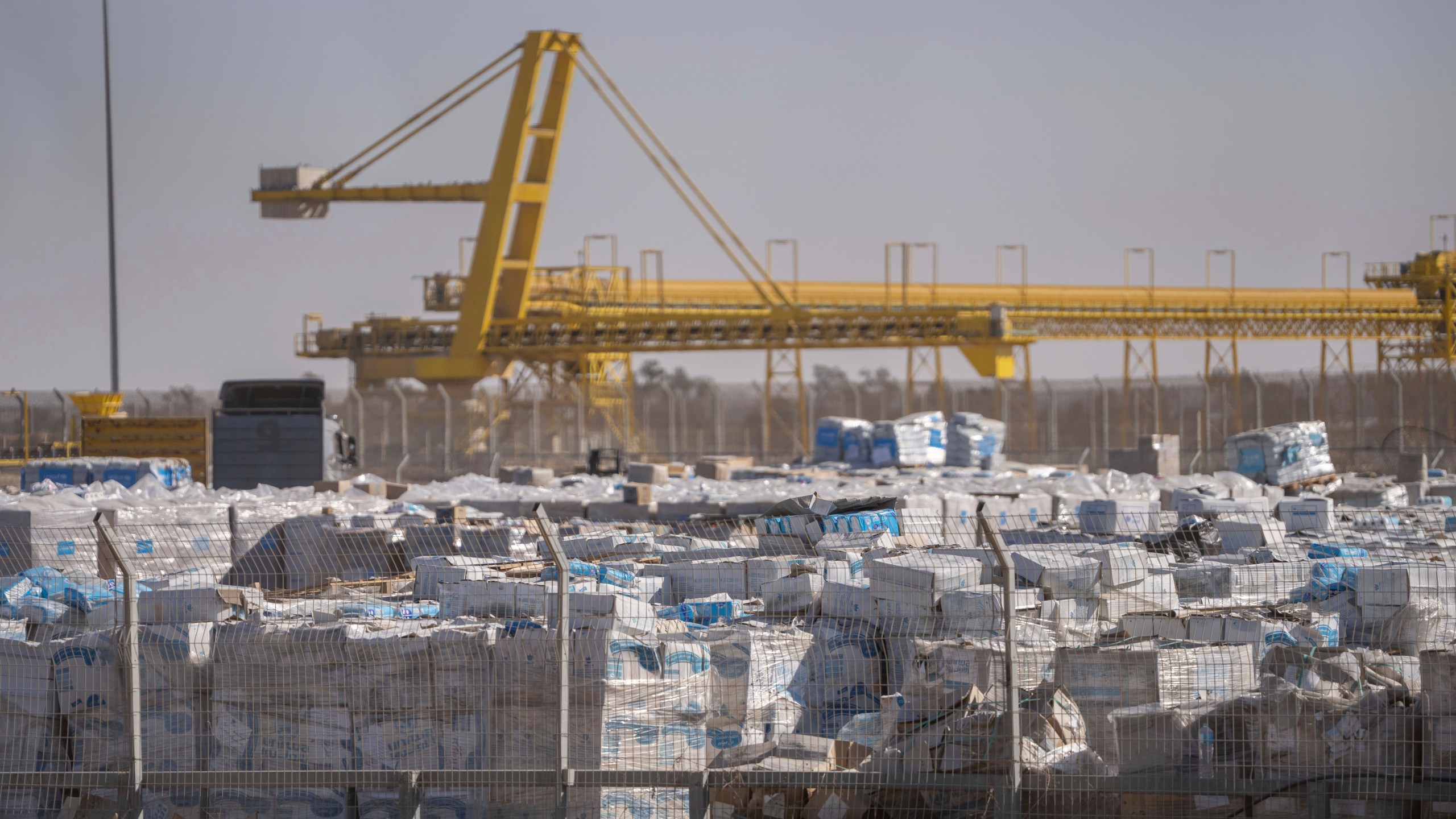 FILE - Humanitarian aid sits, waiting to be picked up on the Palestinian side of the Kerem Shalom aid crossing in the Gaza Strip, on Dec. 19, 2024. (AP Photo/Ohad Zwigenberg, File)