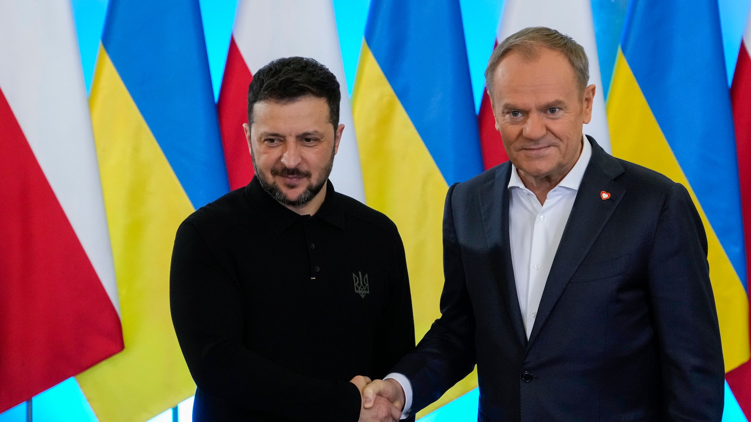 Polish Prime Minister Donald Tusk, right, welcomes Ukrainian President Volodymyr Zelenskyy after the two countries reached an agreement on exhuming Polish victims of WWII-era massacres by Ukrainian nationalists, in Warsaw, Poland, on Wednesday, Jan. 15, 2025. (AP Photo/Czarek Sokolowski)