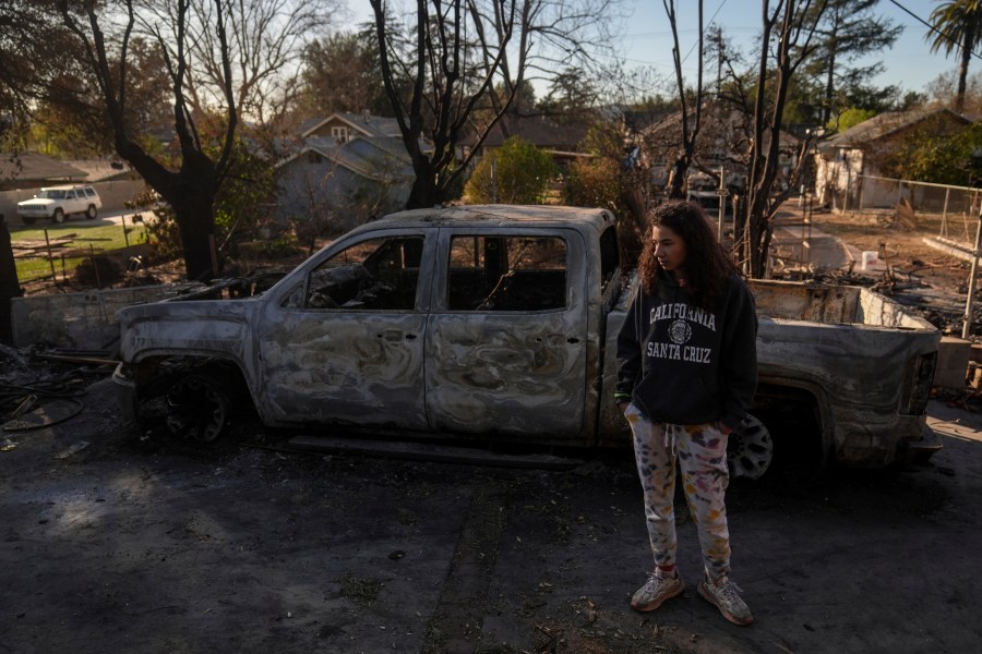 Kaylin Johnson, whose home is one of the few that survived the Eaton Fire in her neighborhood in Altadena, Calif., visits her neighbor's home Tuesday, Jan. 14, 2025. (AP Photo/Jae C. Hong)