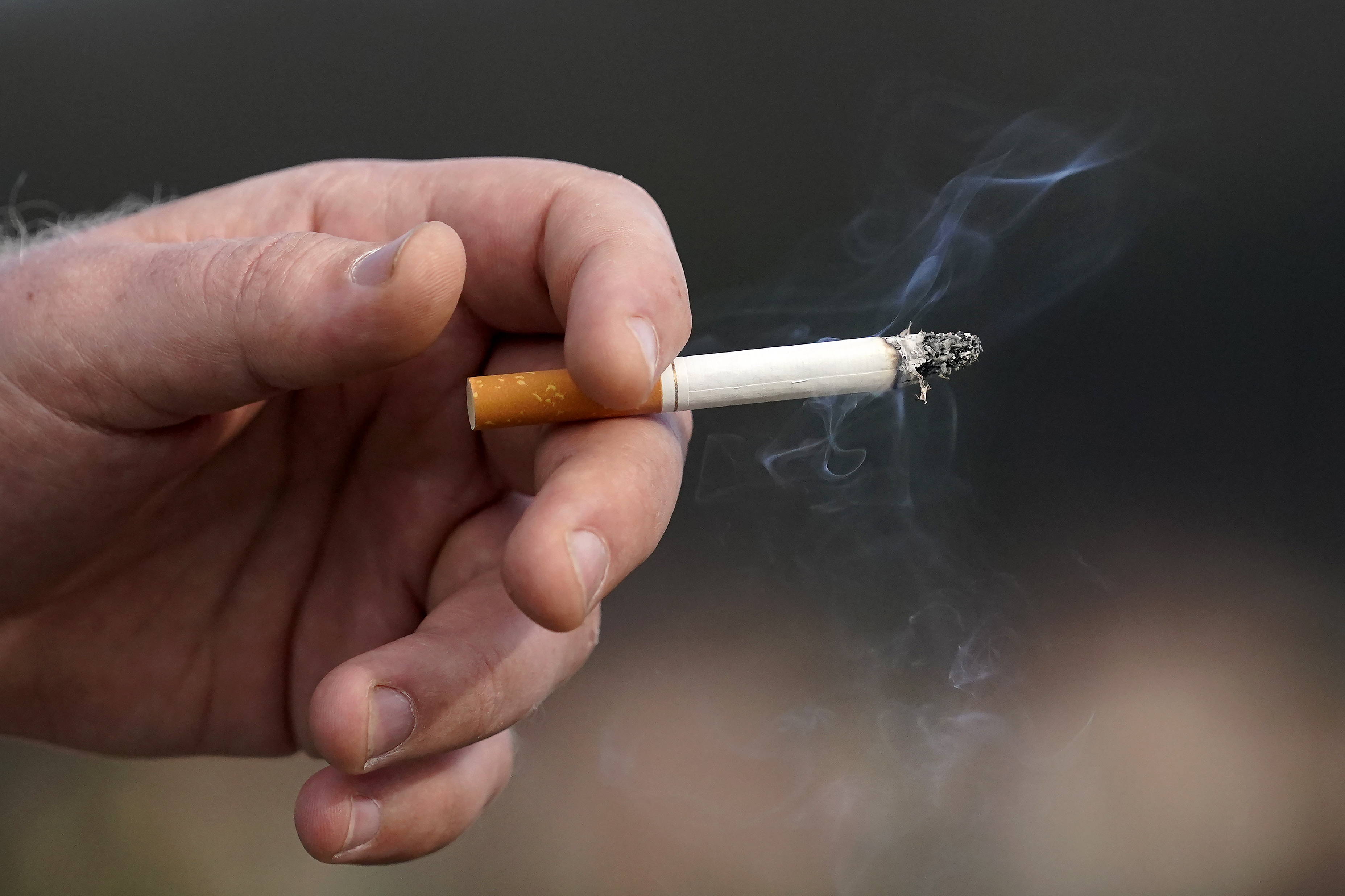 FILE - A man holds a lit cigarette while smoking in San Francisco, Wednesday, Dec. 2, 2020. (AP Photo/Jeff Chiu, File)